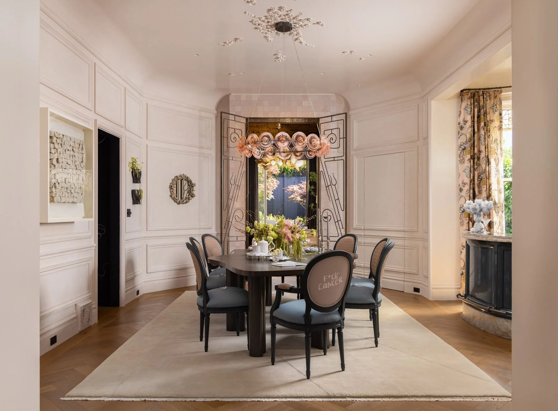 Formal dining room with white paneling, a round table and a floral chandelier, 2315 Broadway, San Francisco Decorator Showcase