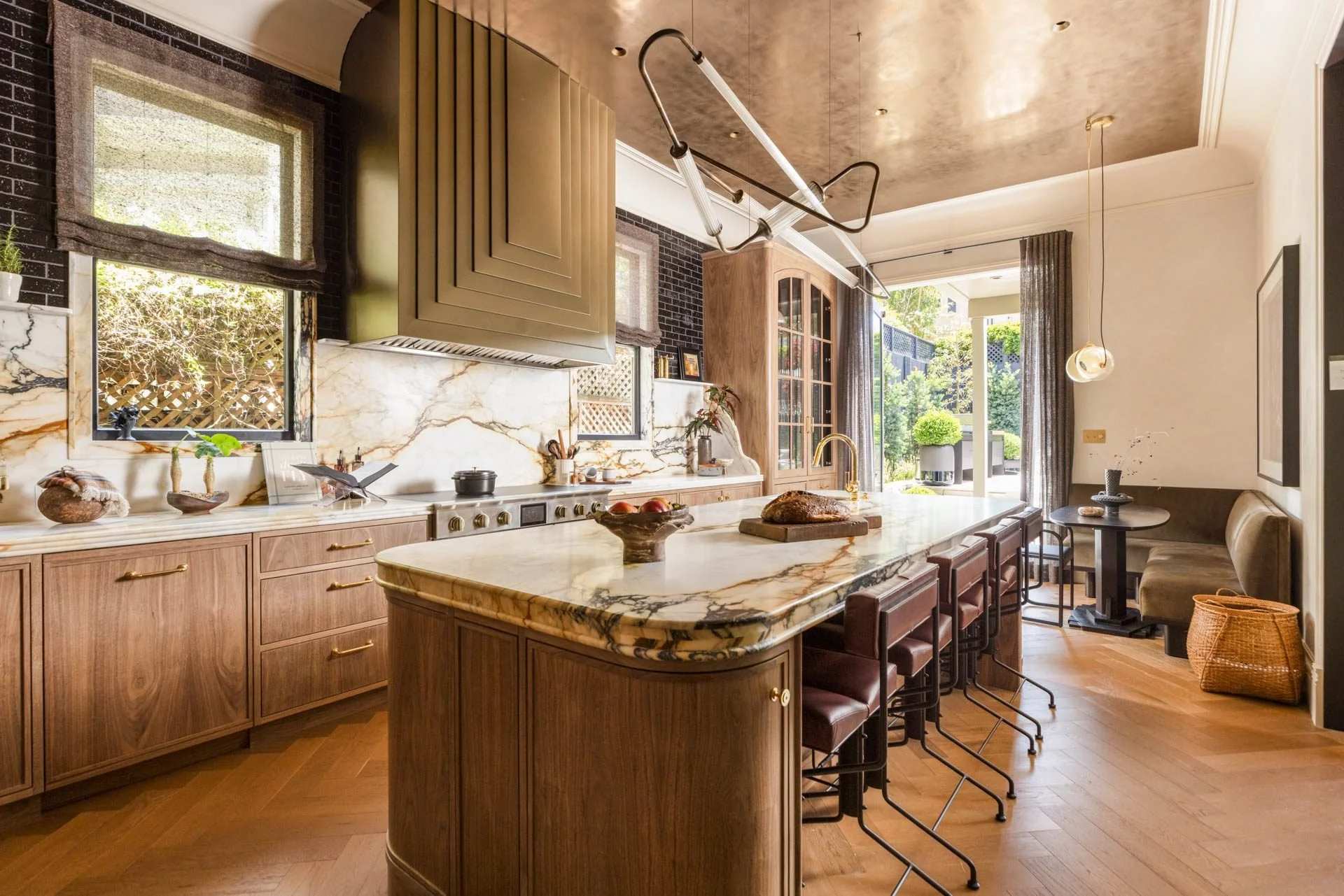 Kitchen with a stone-topped island, oak cabinetry and a brass hood, 2315 Broadway, San Francisco Decorator Showcase