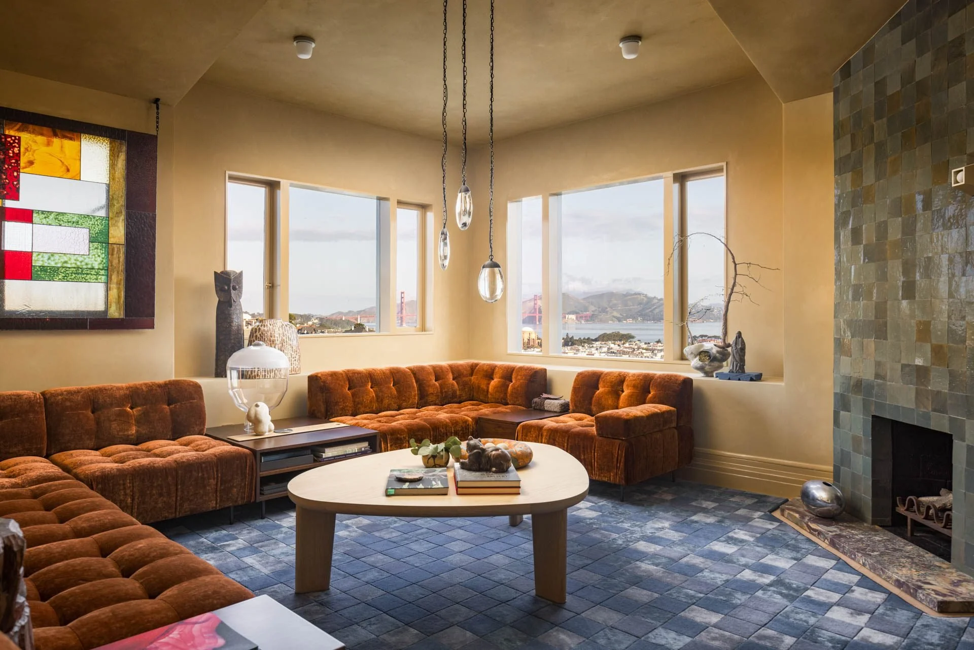 Rust velvet sectional in a lounge with a stained-glass window and bay views, 2315 Broadway, San Francisco Decorator Showcase
