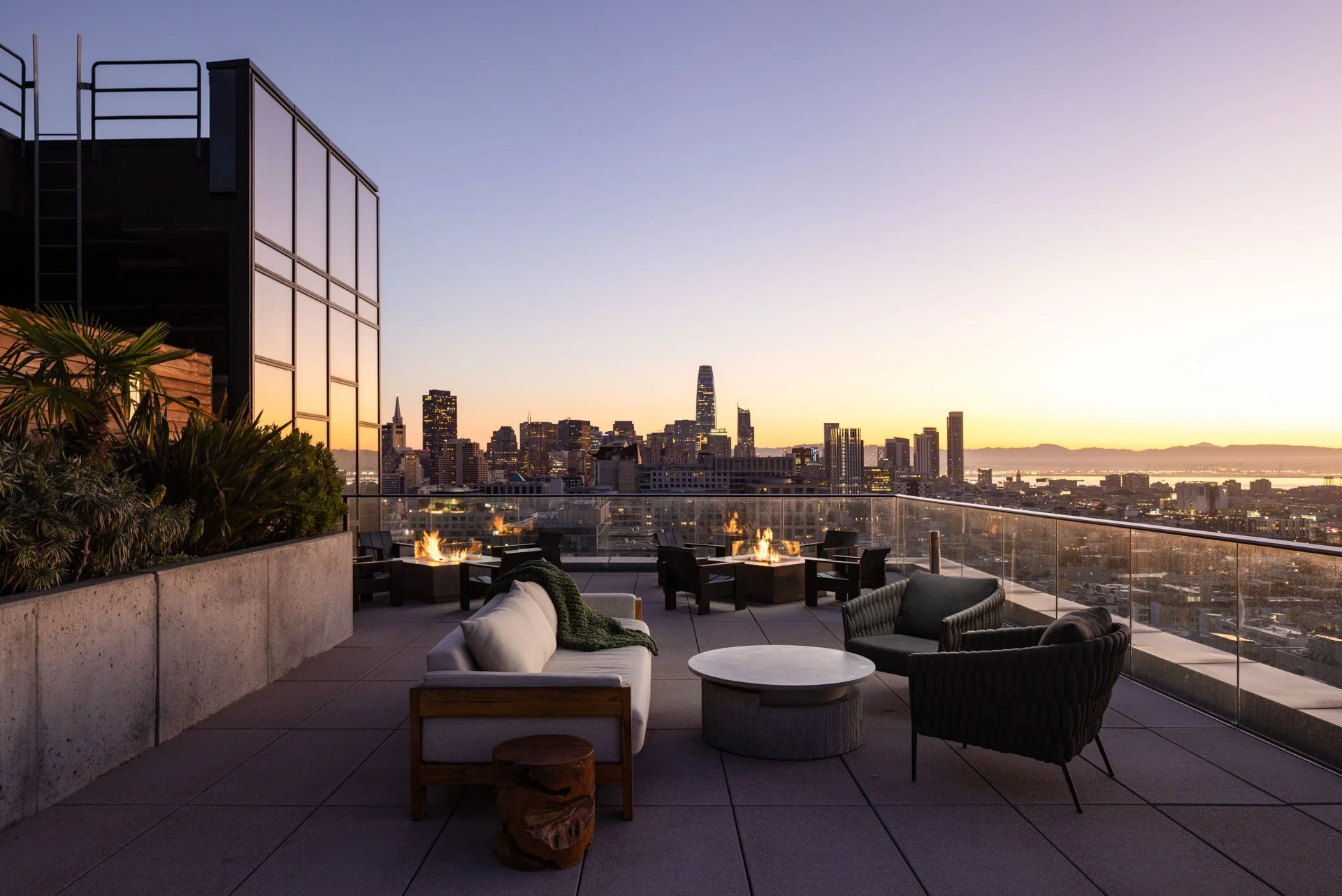 Rooftop lounge with fire pits and sofas at sunset overlooking the San Francisco skyline, NEMA, San Francisco
