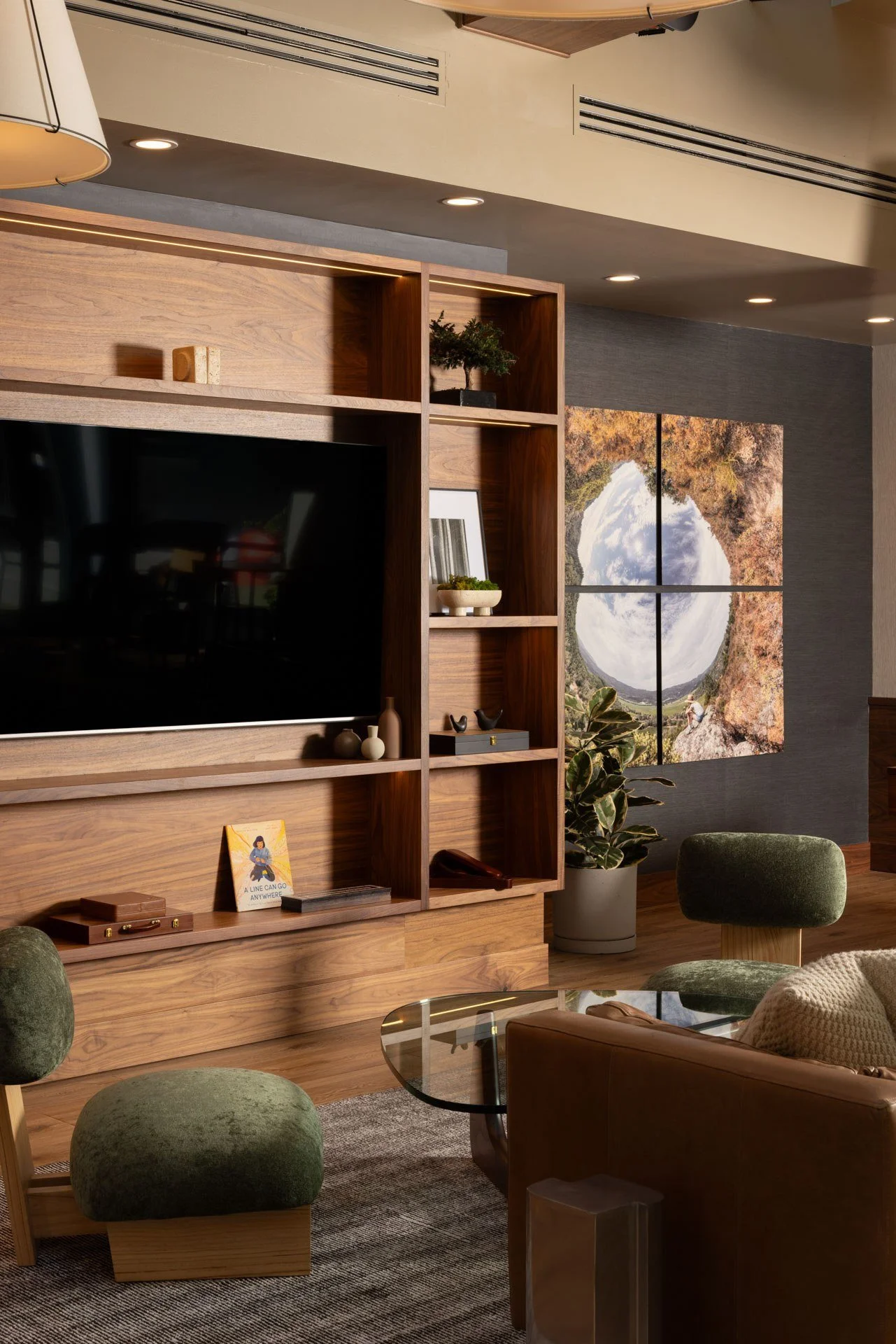 Walnut media wall with built-in shelving and a large landscape artwork in a resident lounge, NEMA, San Francisco