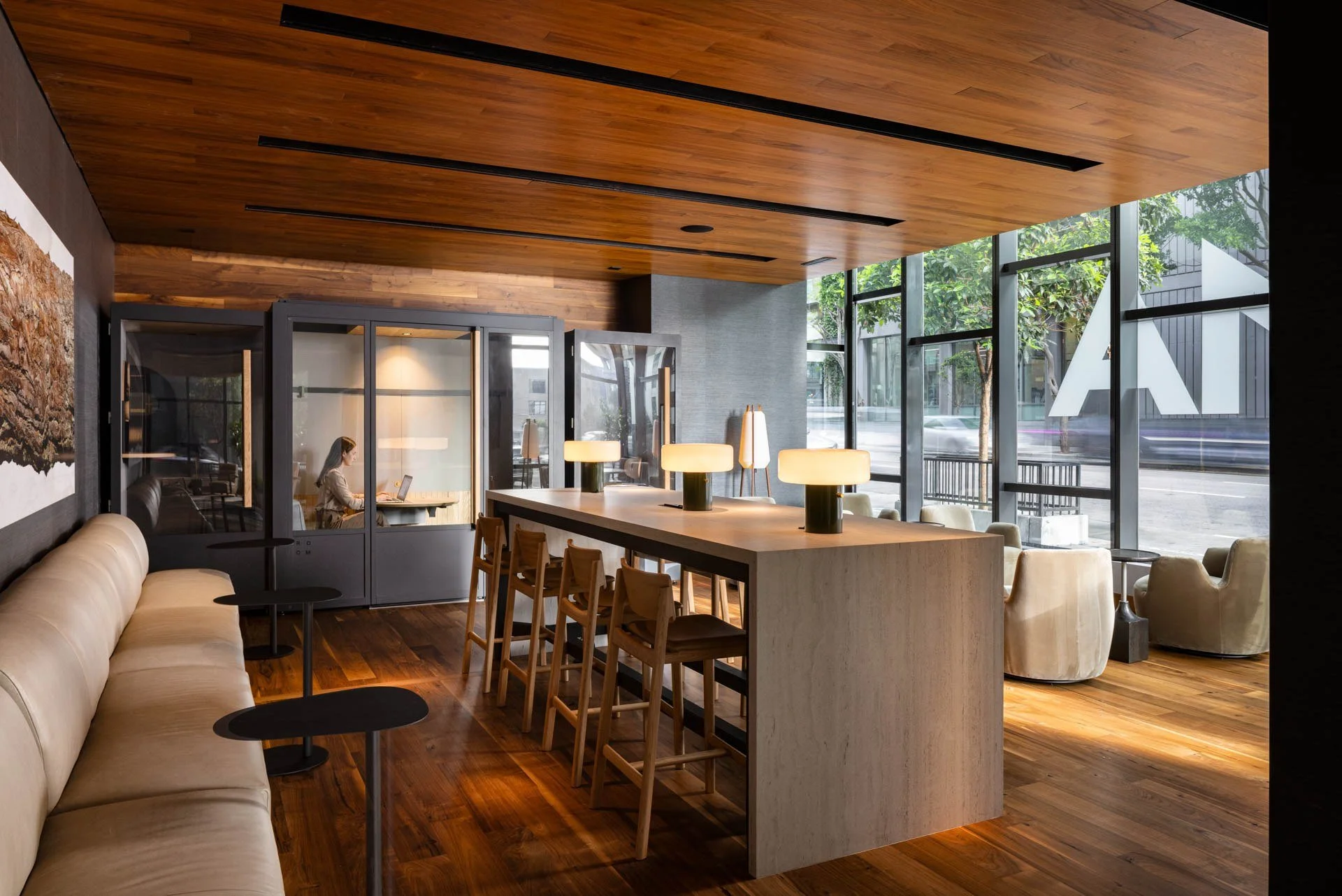 Resident lounge with a stone bar counter, wood ceiling and walnut floors, NEMA, San Francisco