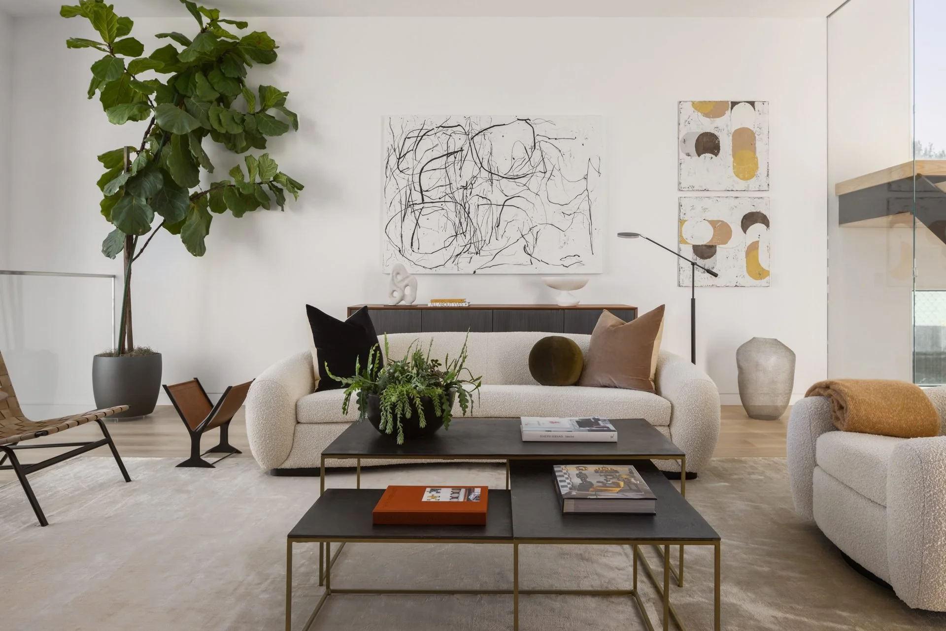 Bright living room with cream sofas, a fiddle-leaf fig and gestural artwork, 119 Telegraph, San Francisco