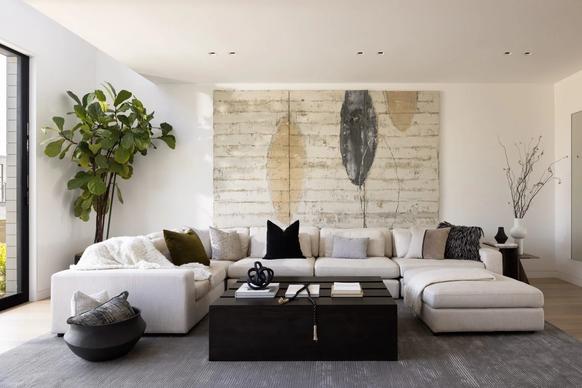 Family room with a white sectional below large abstract artwork, staged by Studio D Home, 119 Telegraph, San Francisco