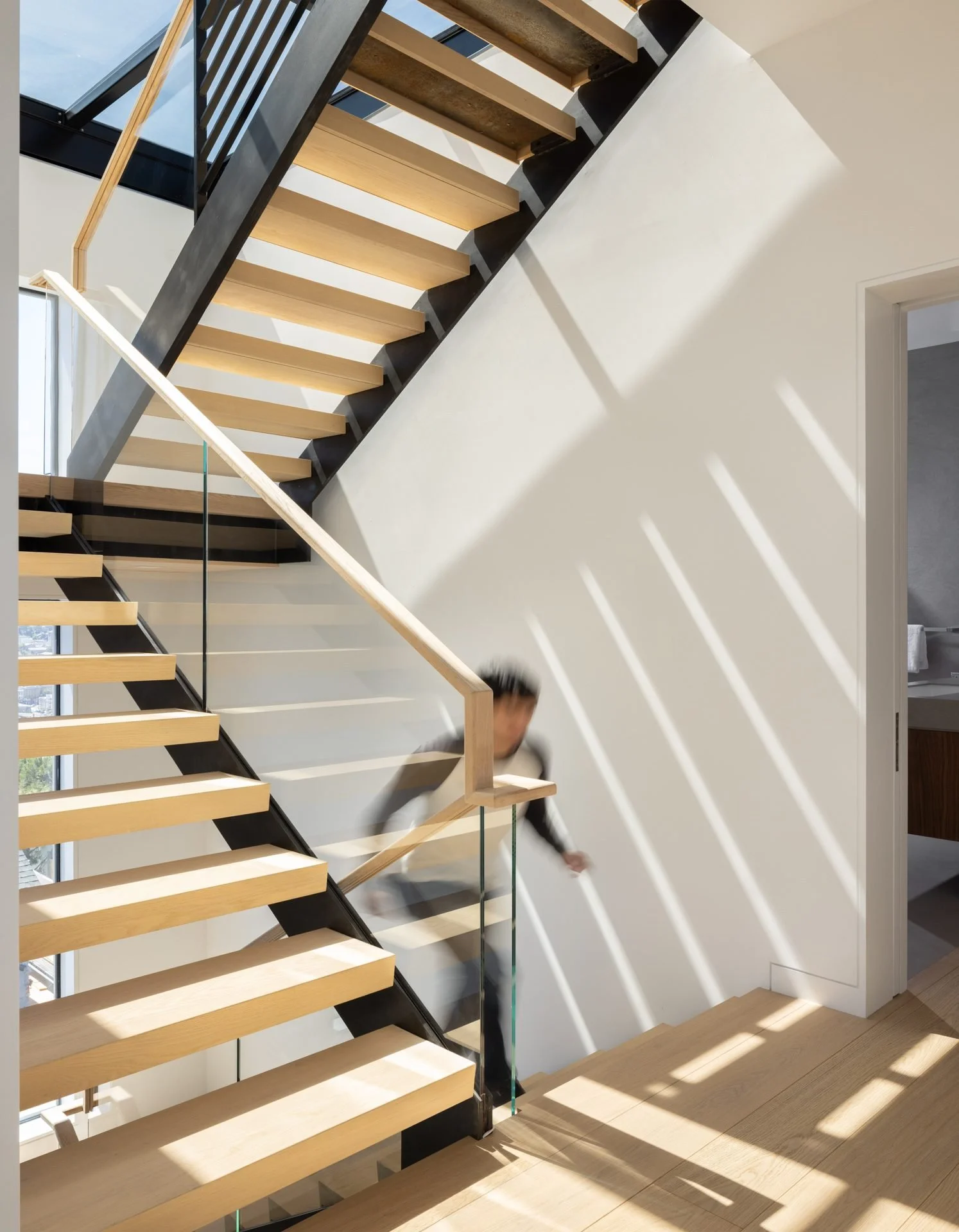 Floating oak stair with steel stringers lit by a skylight, 119 Telegraph, Telegraph Hill, San Francisco