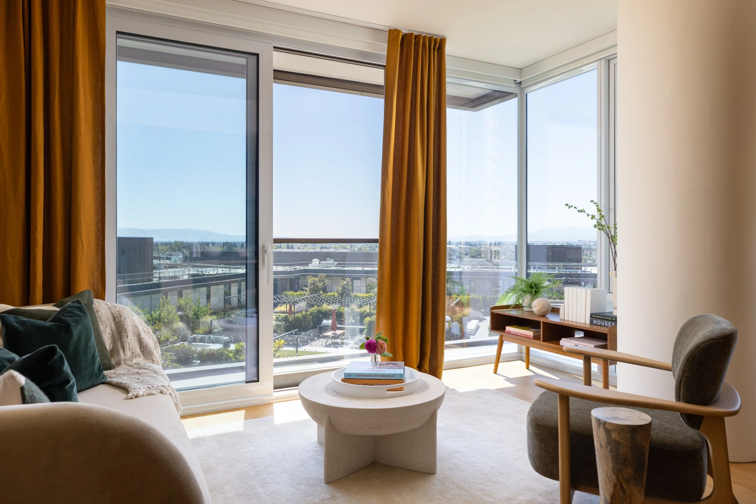 Bright residence living area with saffron curtains, sculptural chairs and city views, The Clara, Santa Clara