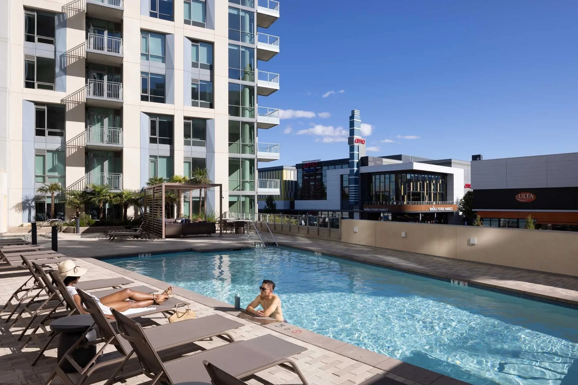 Residents at the podium pool with loungers and cabanas beside the tower, The Martin at CityLine, Sunnyvale