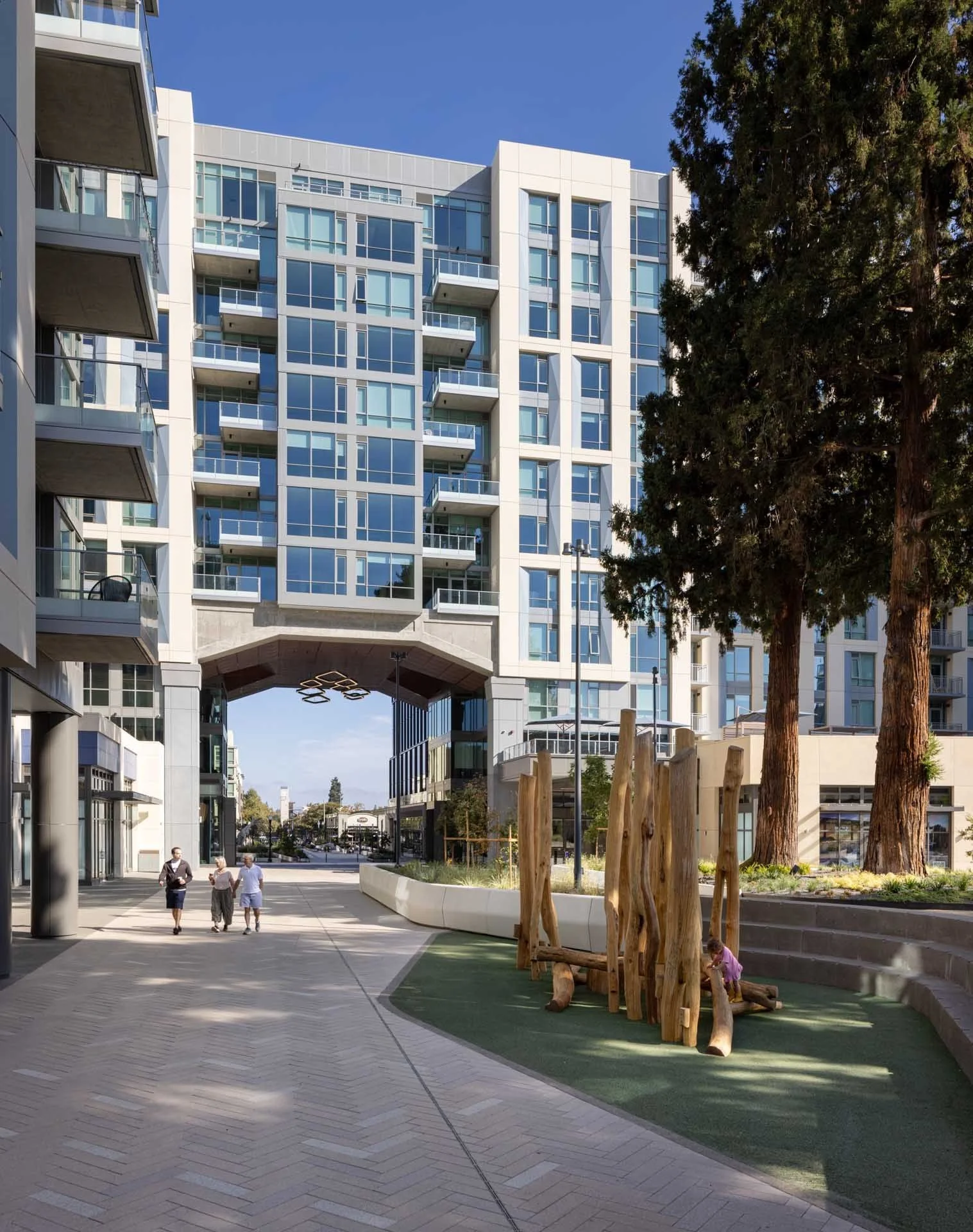 Pedestrian path through a landscaped courtyard toward a sky bridge, The Martin at CityLine, Sunnyvale