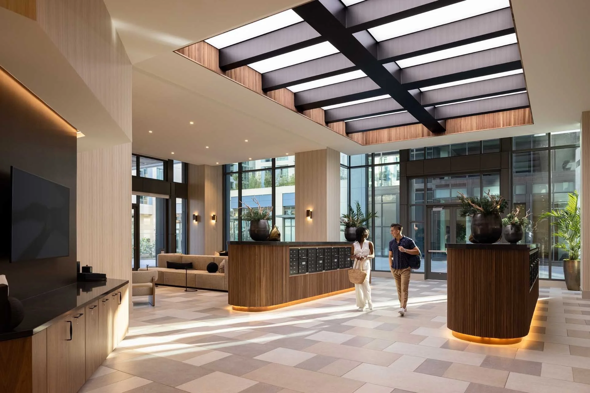 Double-height leasing lobby with skylight beams and wood reception desks, The Martin at CityLine, Sunnyvale