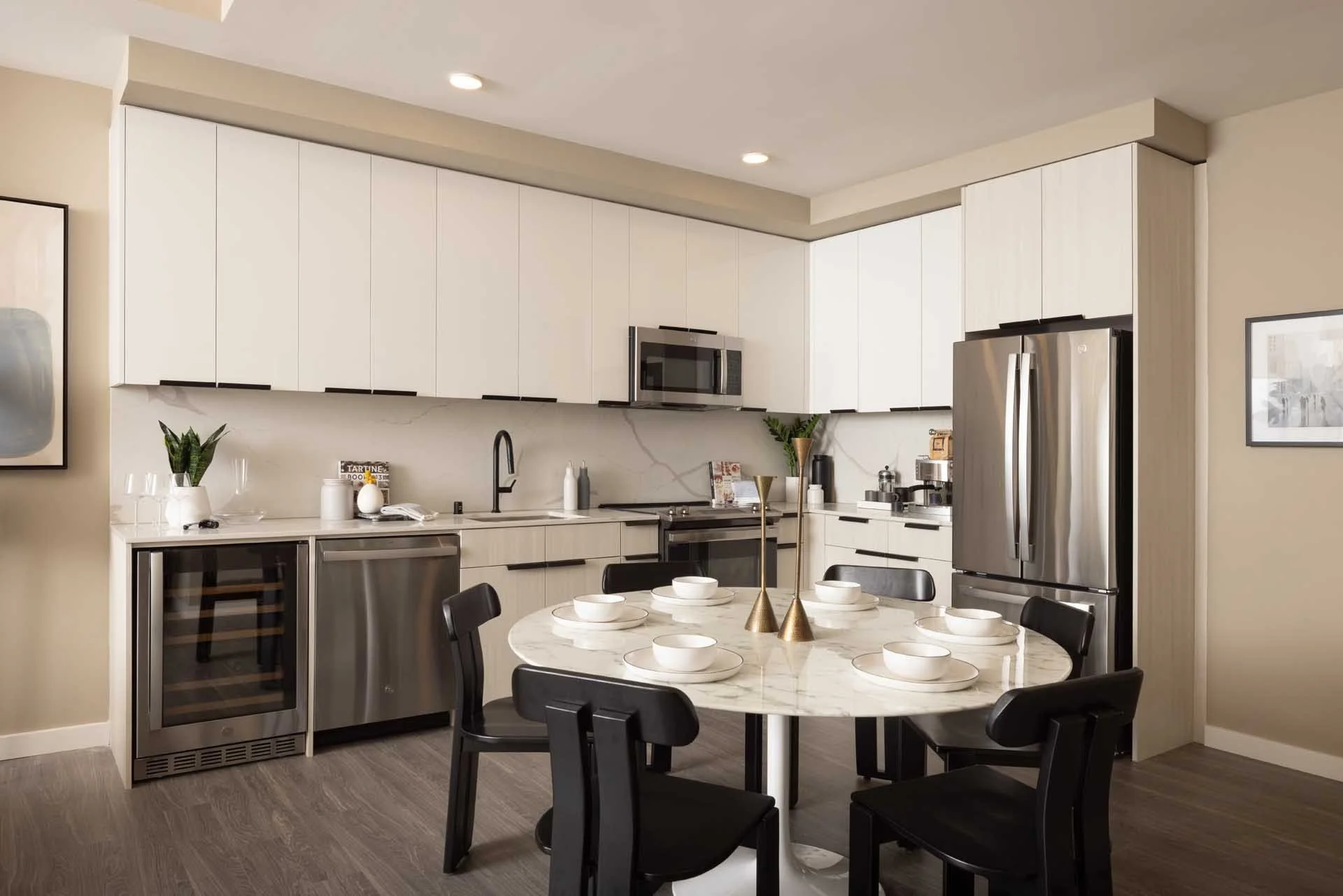 Apartment kitchen with white cabinets, stainless appliances and a round dining table, The Martin, Sunnyvale