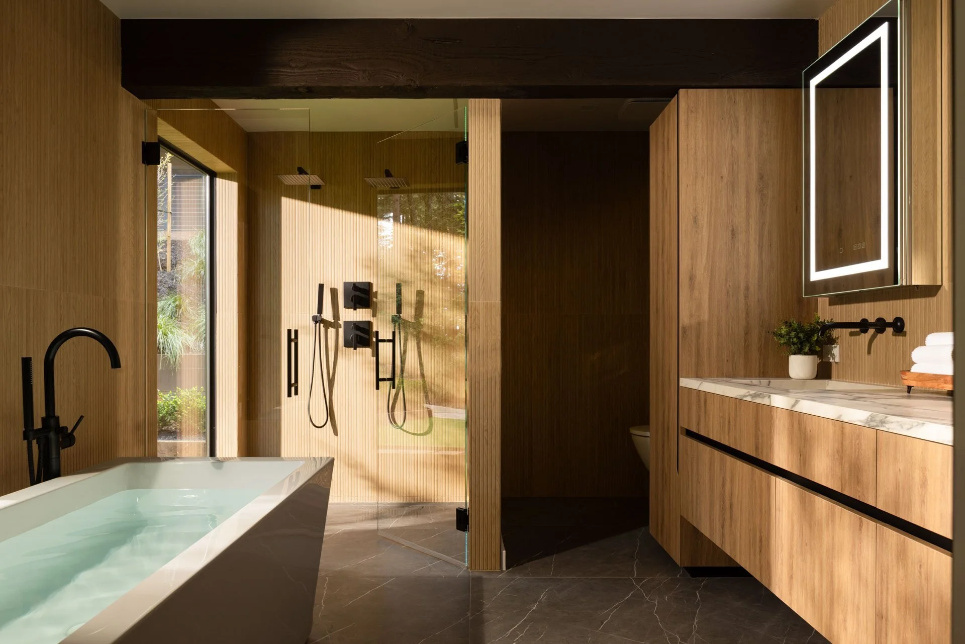 Primary bathroom with a soaking tub, glass shower and oak-paneled walls in morning light, 238 Summit Drive, Corte Madera