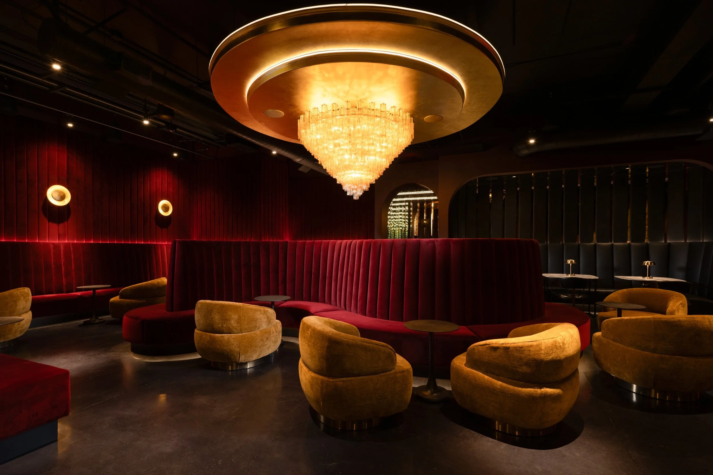 Velvet cocktail lounge with a gold crystal chandelier, red banquettes and mustard swivel chairs, Matrix Bar, Napa