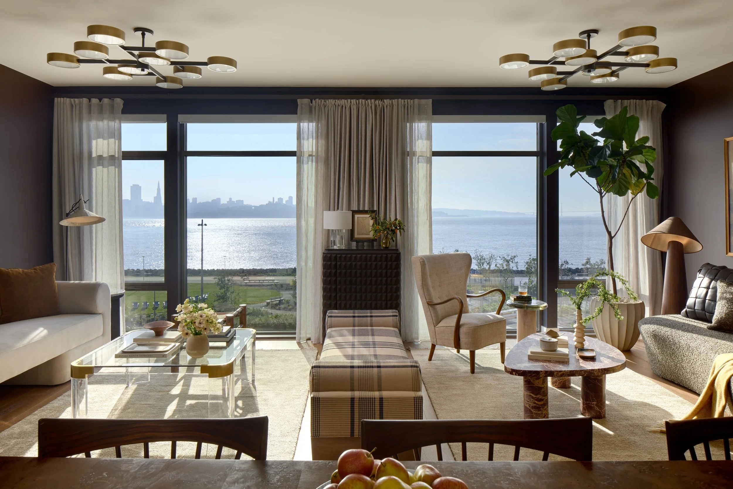 Model residence living and dining area with low armchairs and a view across the Bay, 490 Avenue of the Palms, Treasure Island