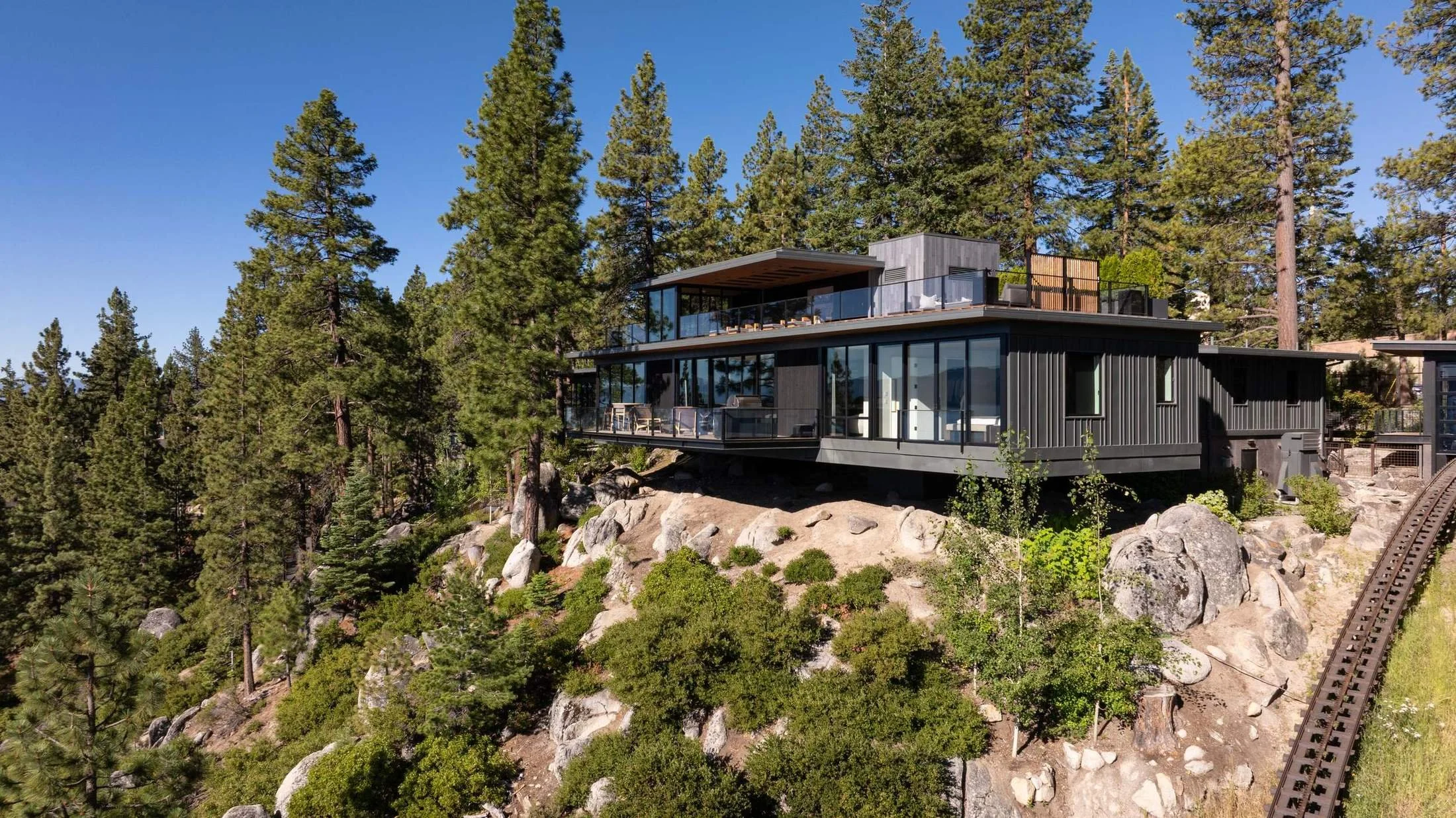 Aerial view of the house on its granite hillside among the pines, Lake Tahoe Residence