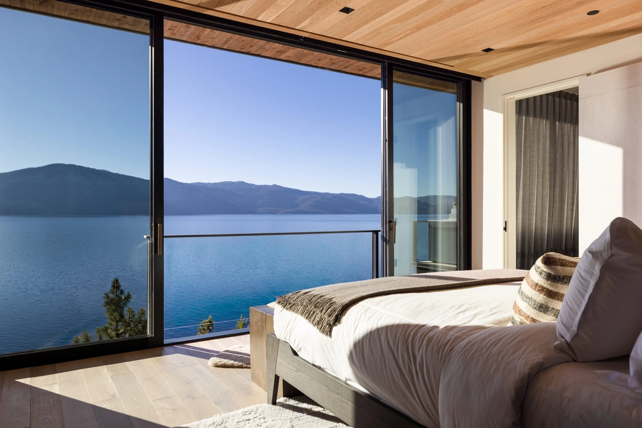 Bedroom with floor-to-ceiling glass looking across Lake Tahoe, Lake Tahoe Residence