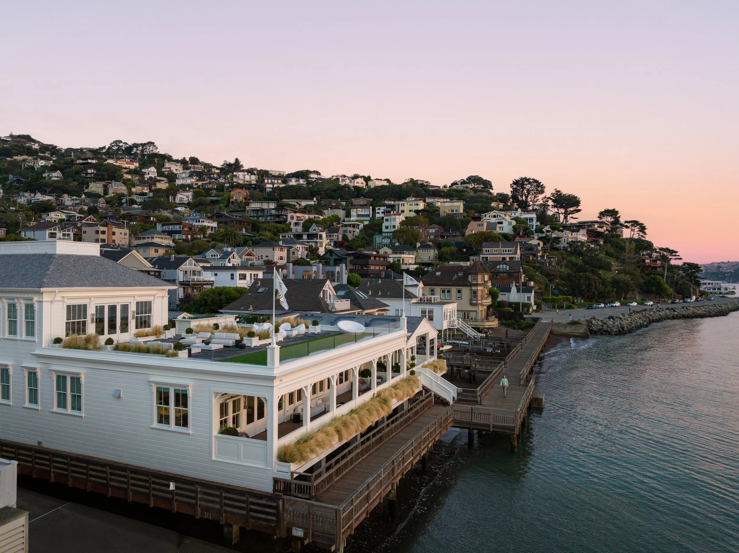 Aerial of Valhalla on its pier at dusk below the Sausalito hills, 201 Bridgeway