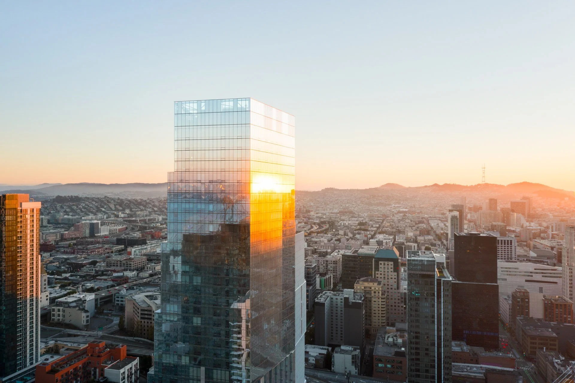 The Avery's glass facade catching the sunset over San Francisco