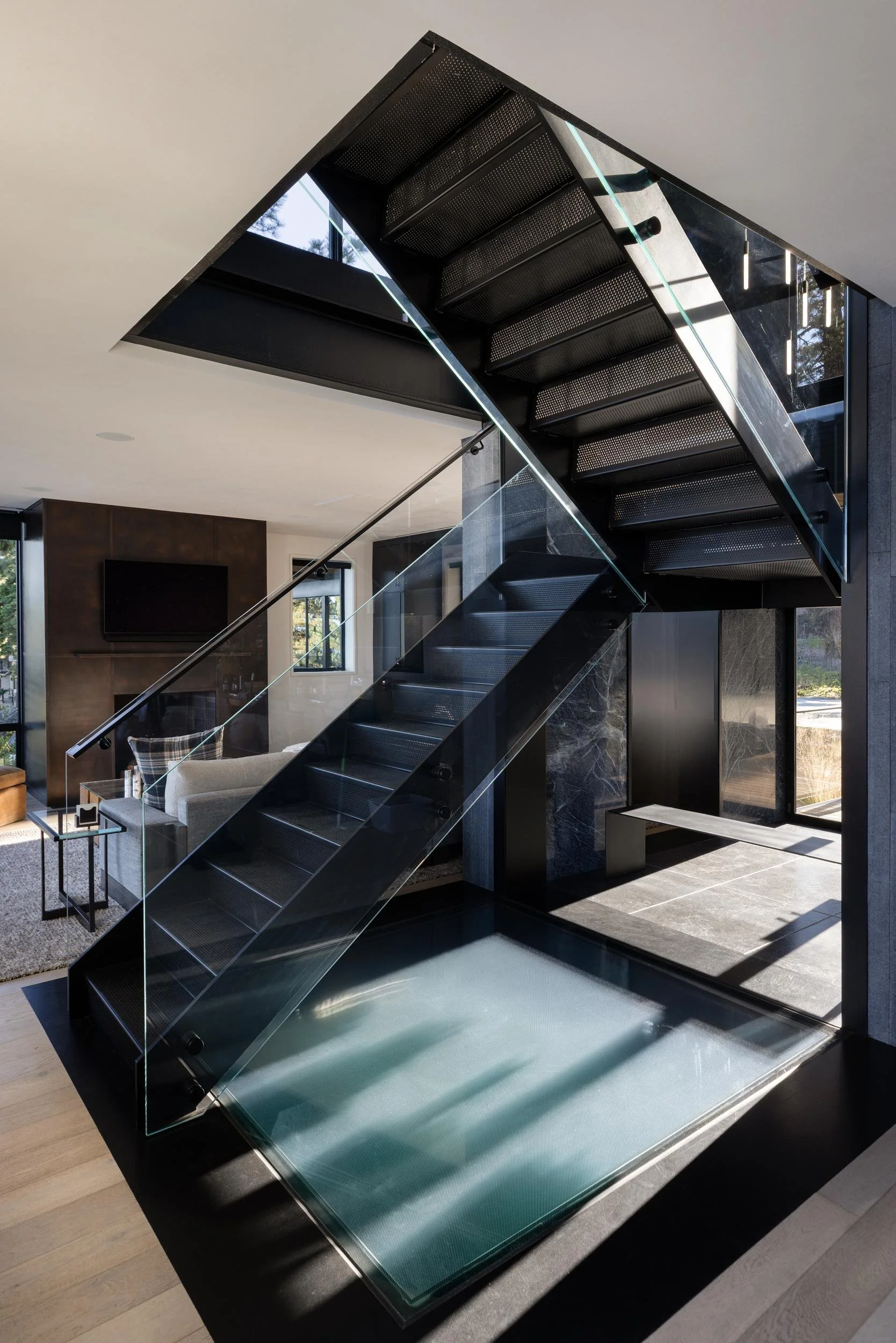 Steel and glass stair rising above a glass floor, Lake Tahoe Residence
