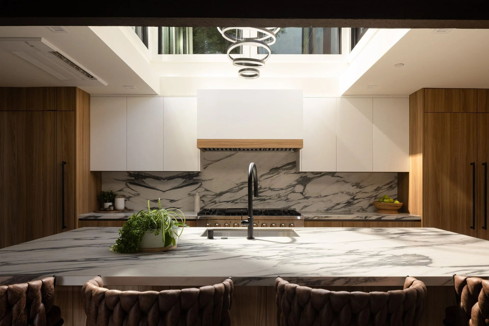Kitchen with a bookmatched marble island, wood cabinetry and a skylight, 238 Summit Drive, Corte Madera