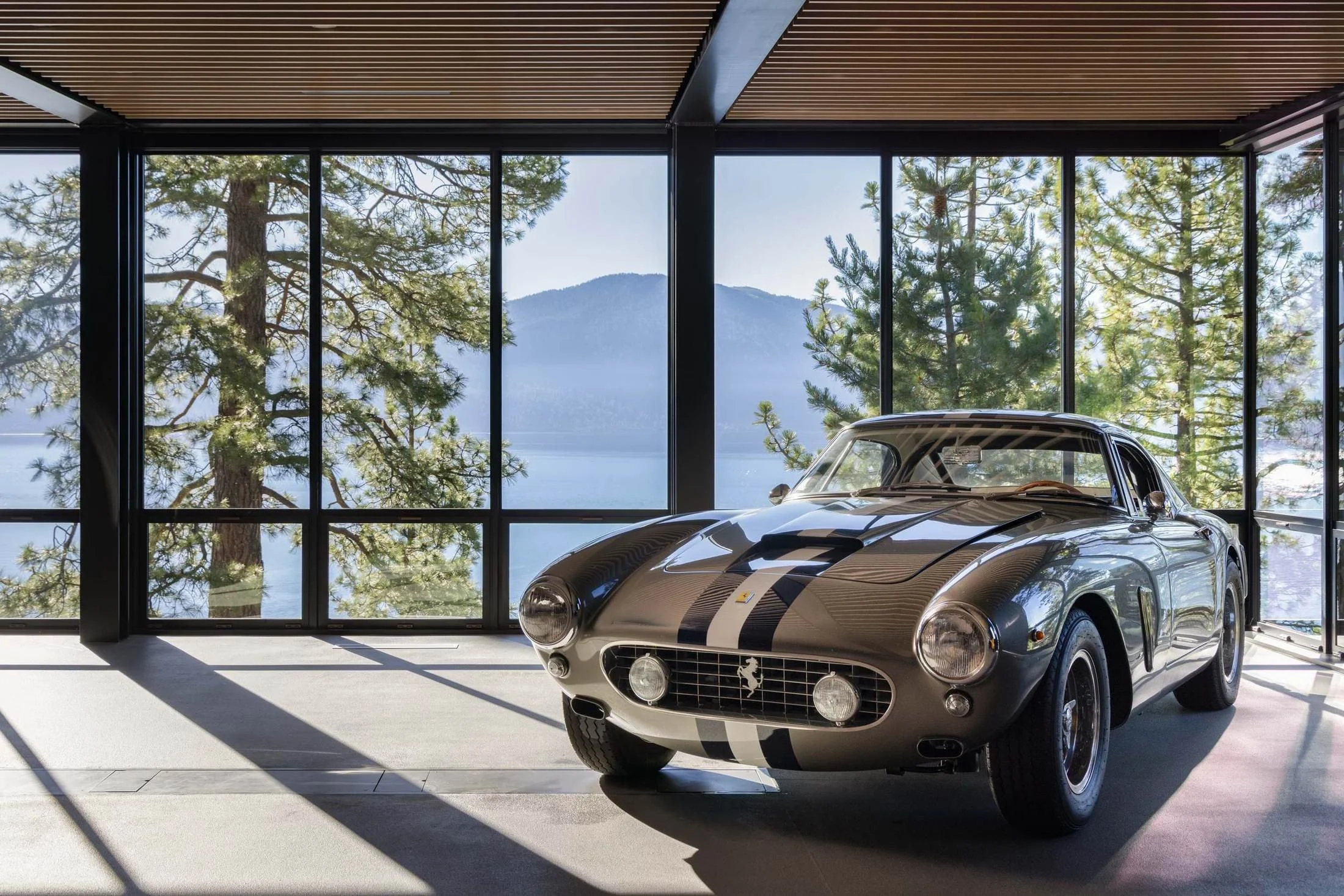 Glass-walled garage with a classic car and views across Lake Tahoe, Lake Tahoe Residence