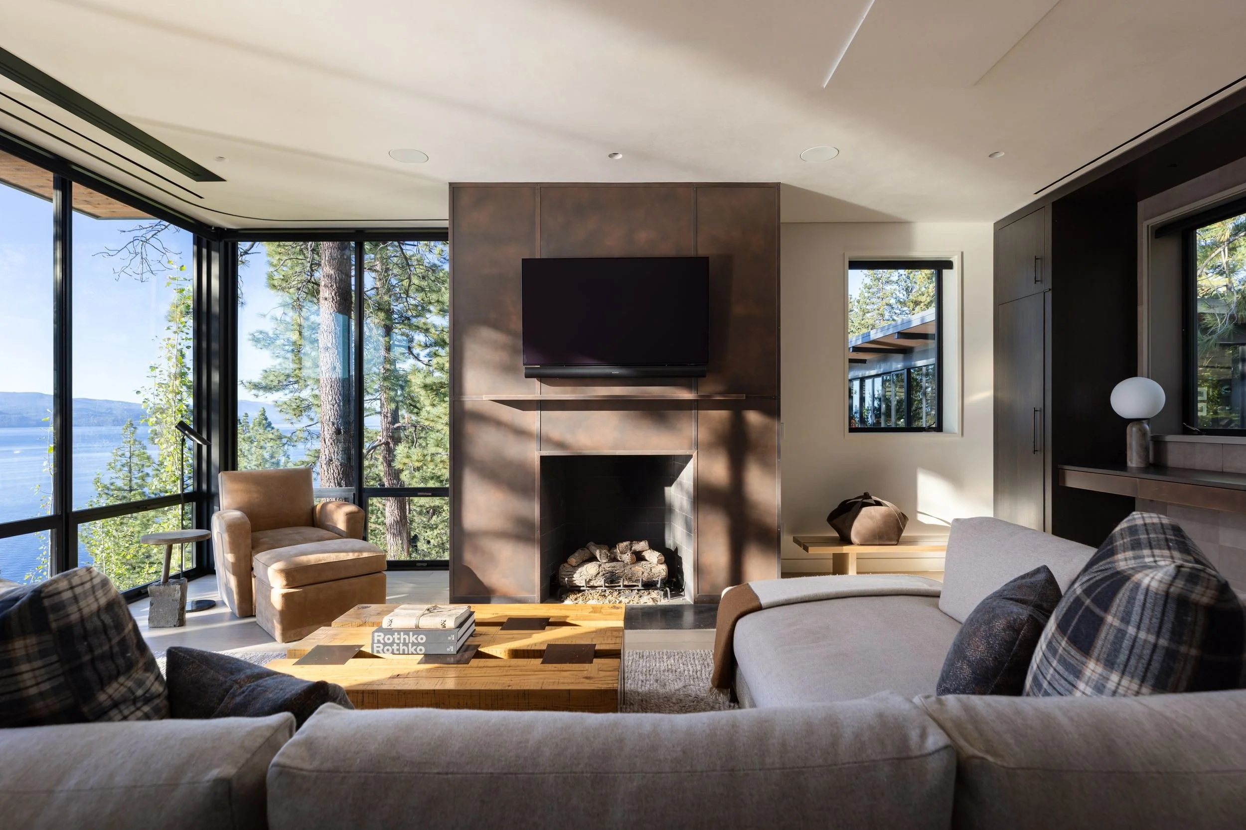 Living room with stone fireplace and corner windows over Lake Tahoe, Lake Tahoe Residence