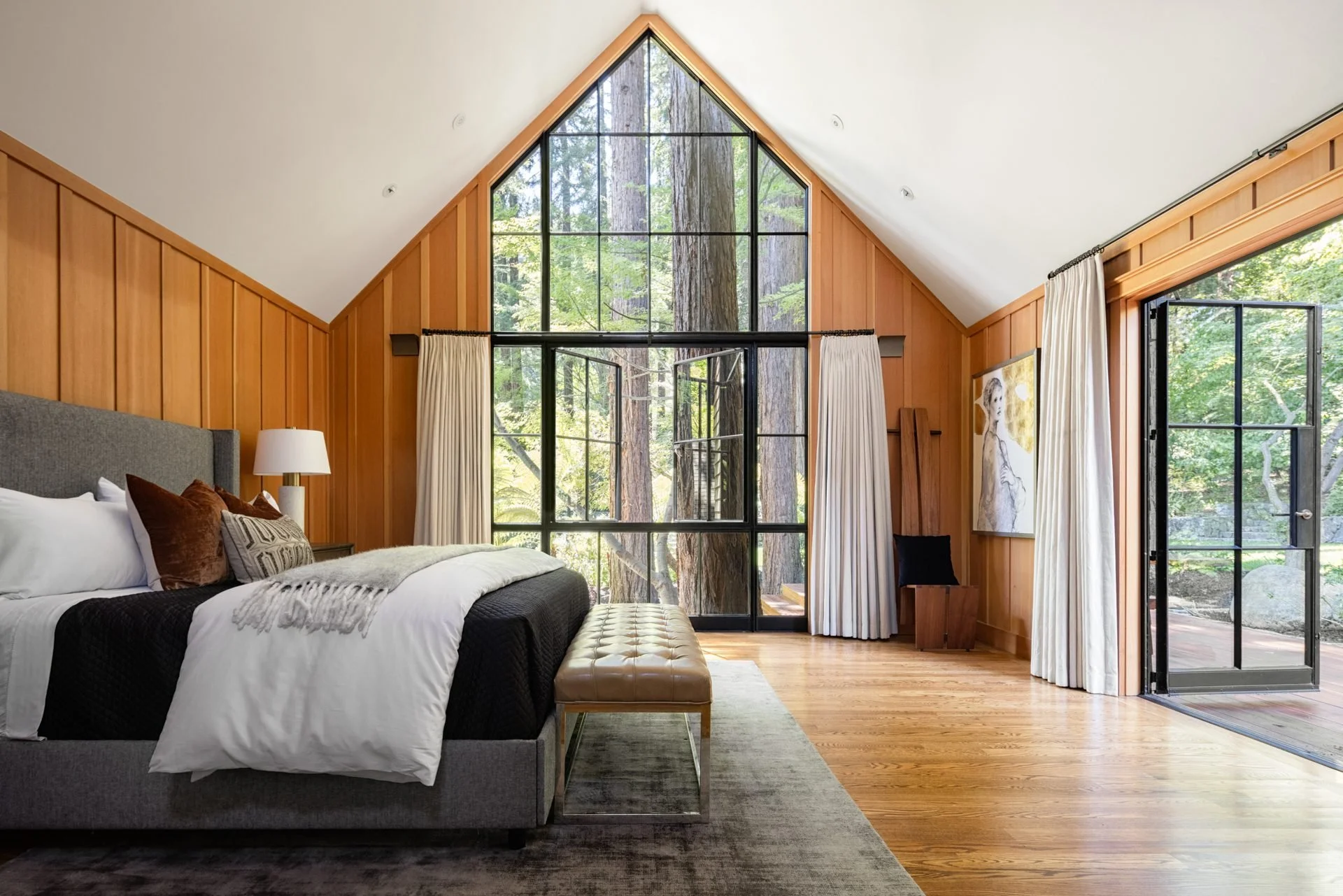 Primary bedroom under a glass gable framing the redwoods, 16 Woodside, Mill Valley
