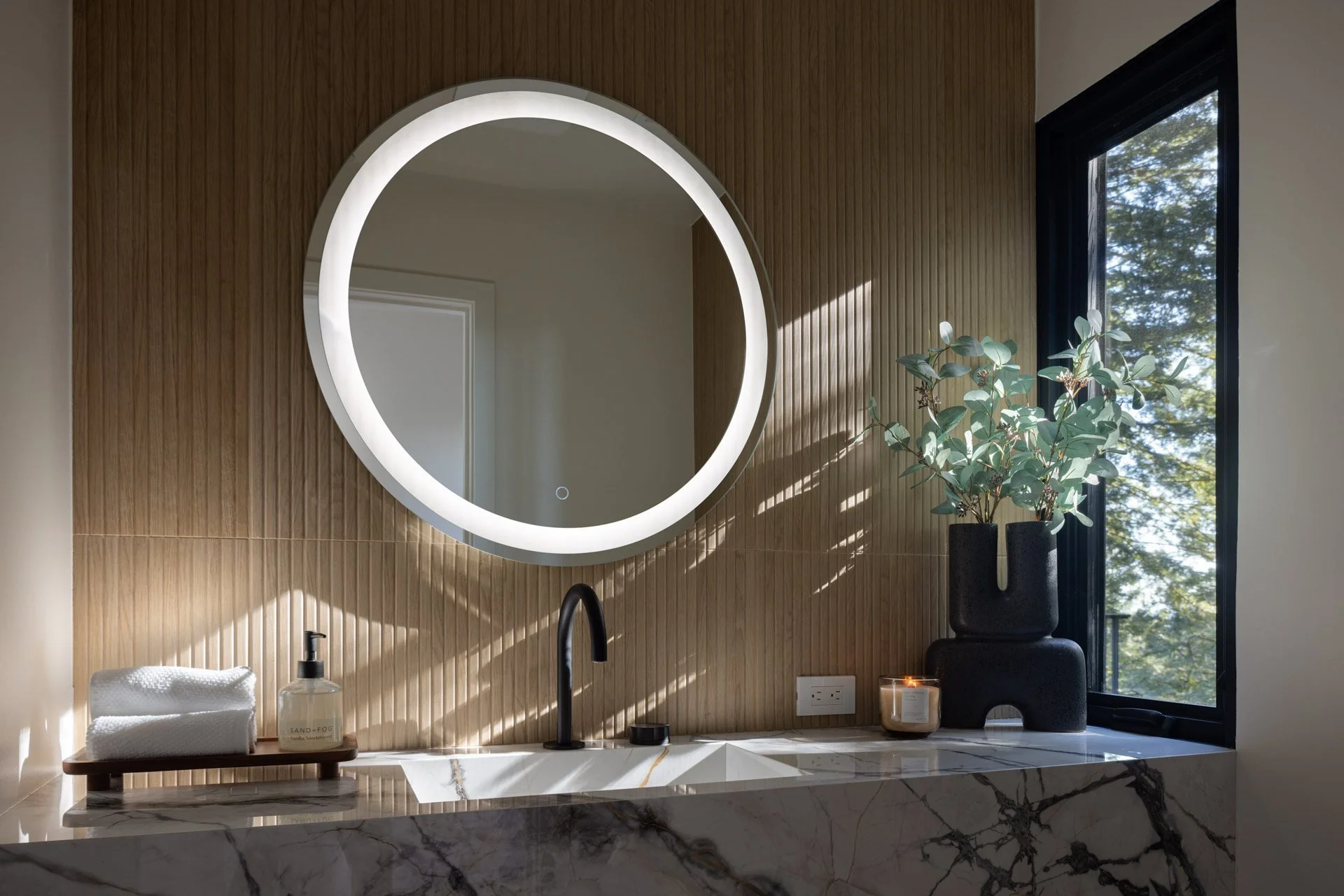 Powder room with a round backlit mirror, marble vanity and slatted wood wall, 238 Summit Drive, Corte Madera