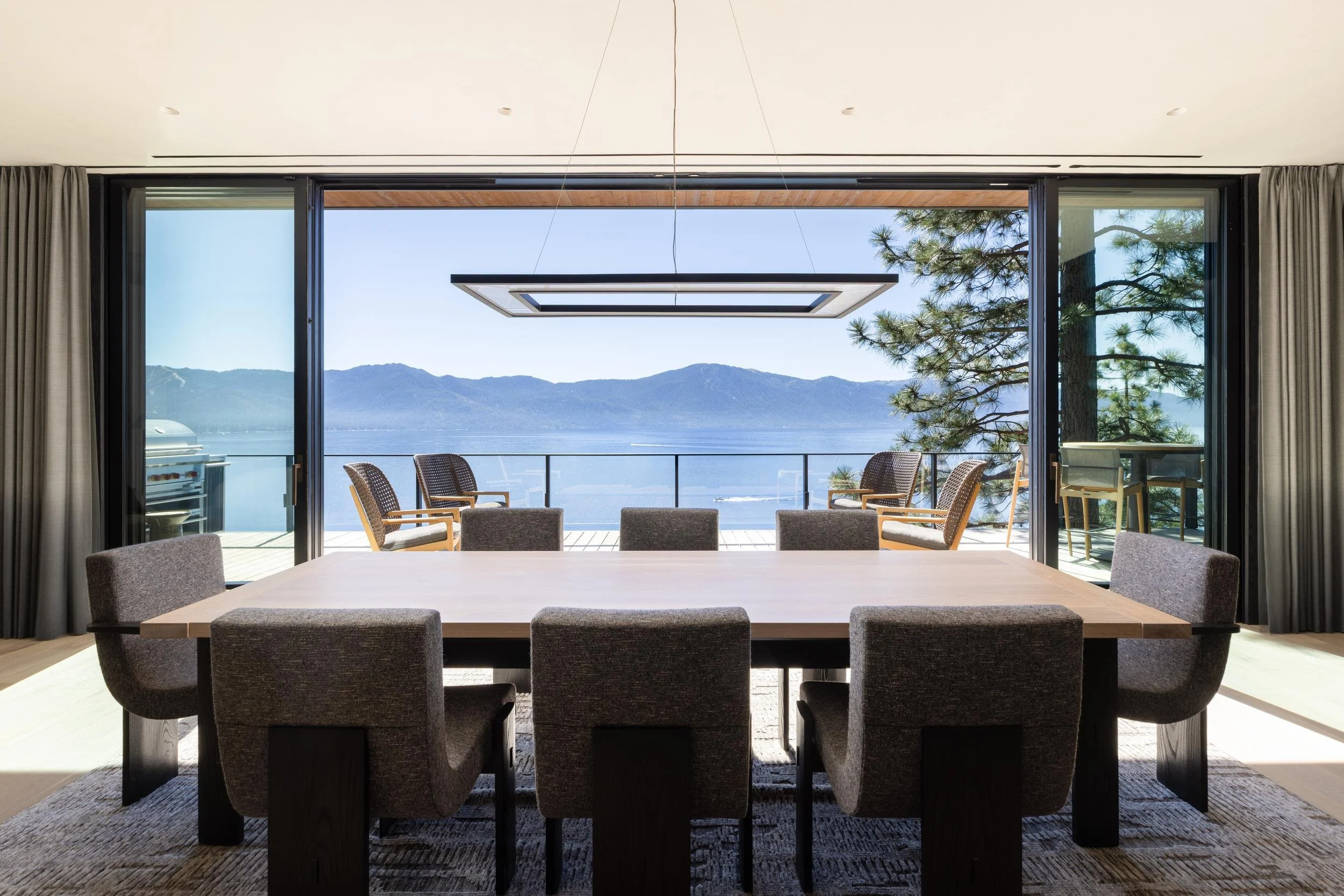Dining table facing a wall of open glass and the lake, Lake Tahoe Residence