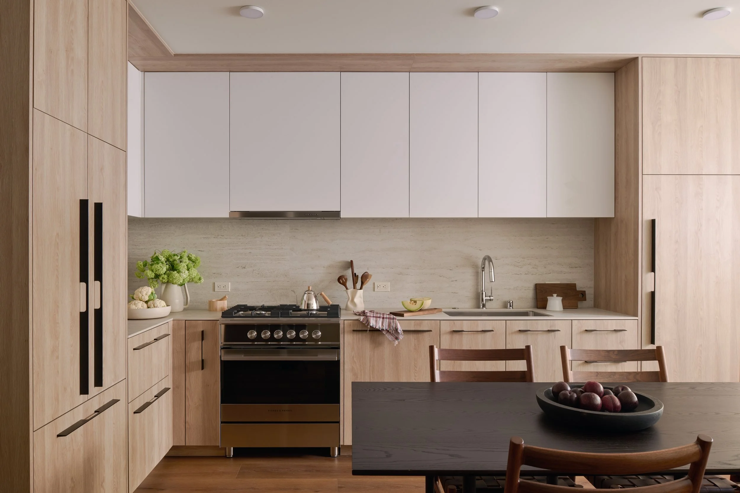 Kitchen with flat-panel oak and white cabinetry, a gas range and a dining table, 490 Avenue of the Palms, Treasure Island
