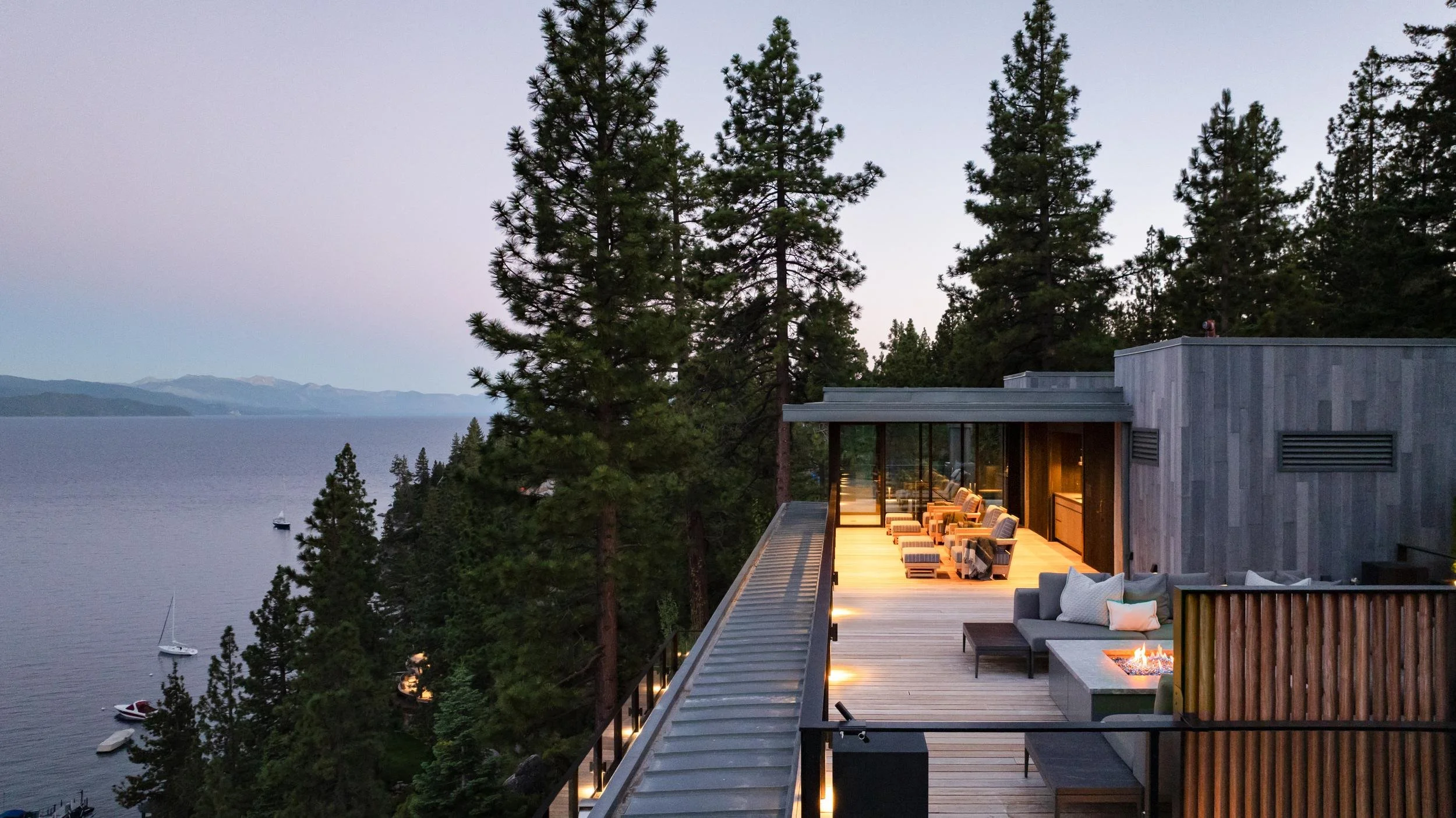 Rooftop deck and lounge among the pines at dusk above the lake, Lake Tahoe Residence