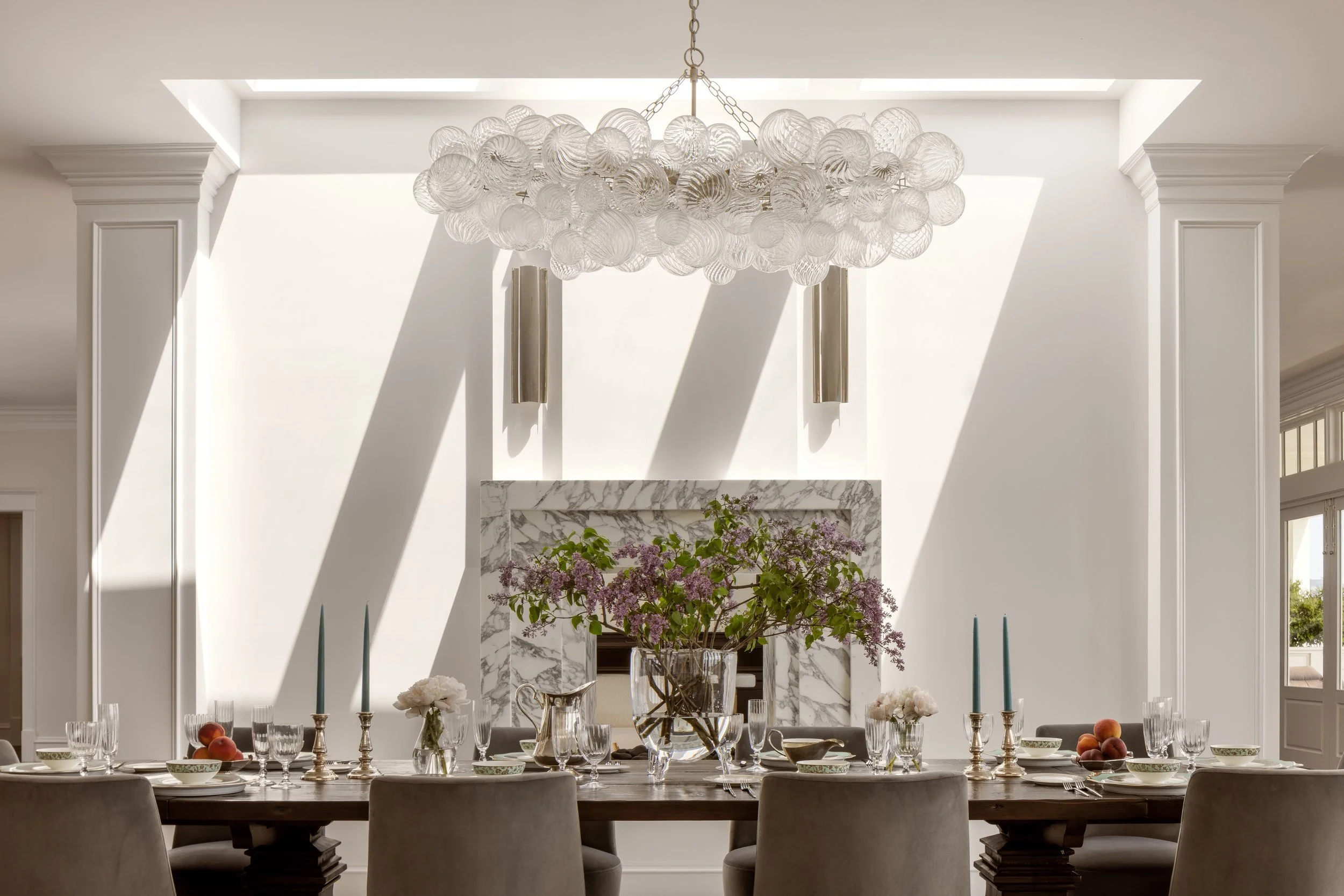 Dining room set for dinner under a bubble glass chandelier beside the marble fireplace, Valhalla, Sausalito