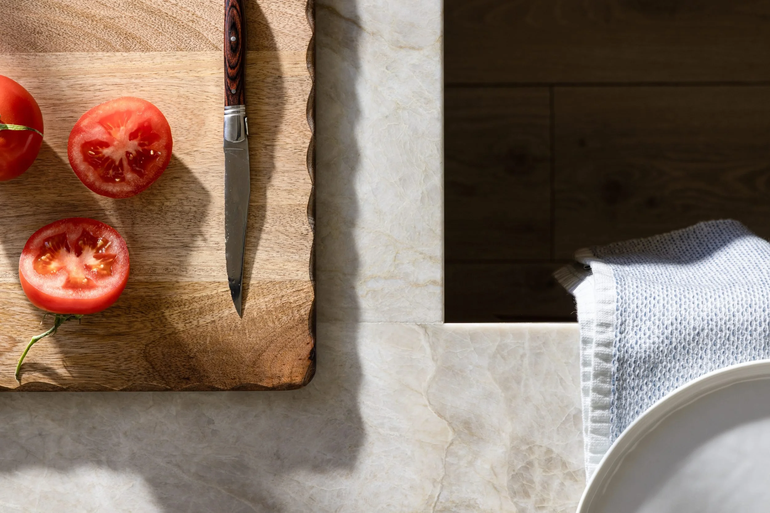 Overhead detail of tomatoes on a cutting board and quartzite counter edge, 283 Fairway Drive, Barlow Design
