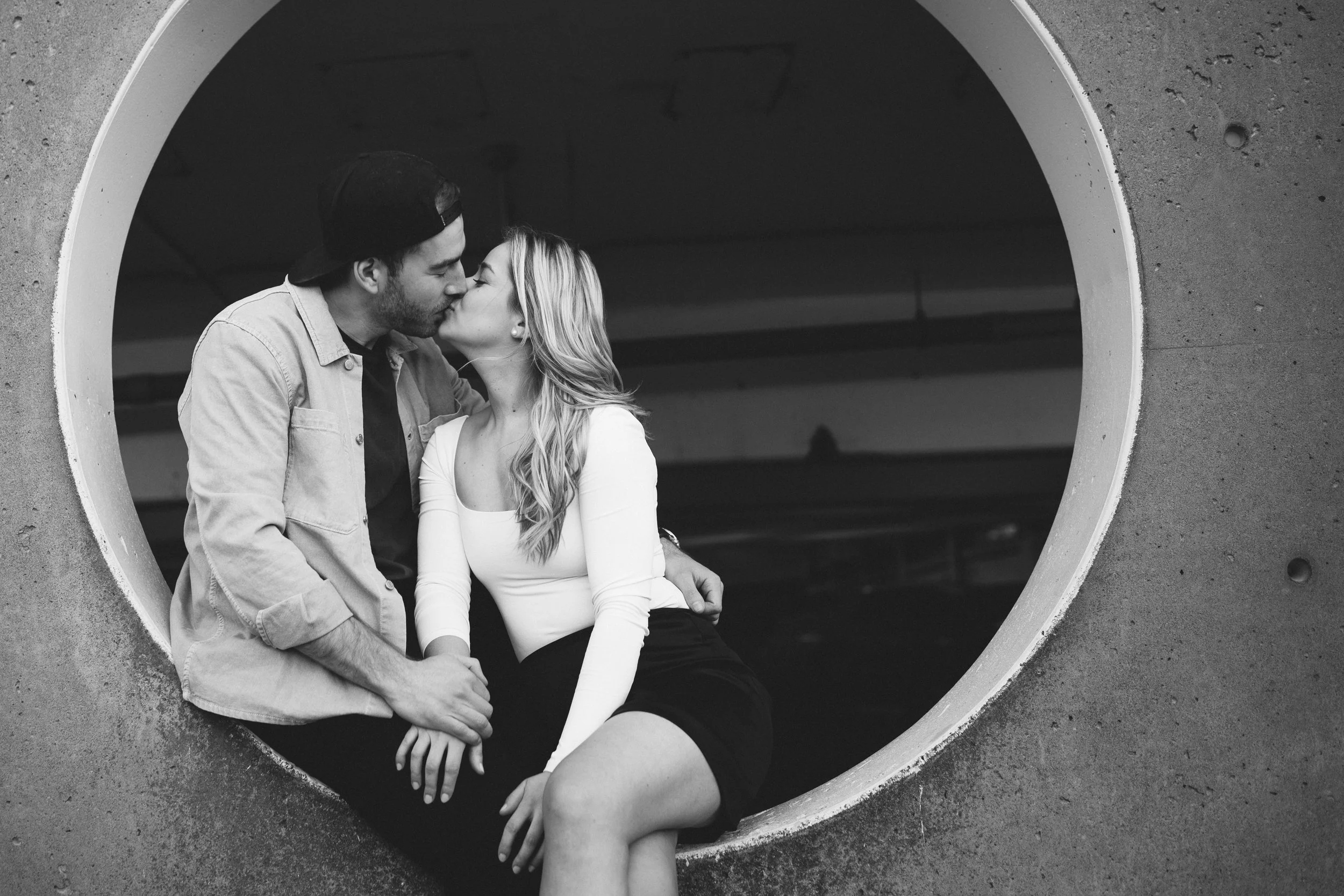 engaged couple kissing in parking garage