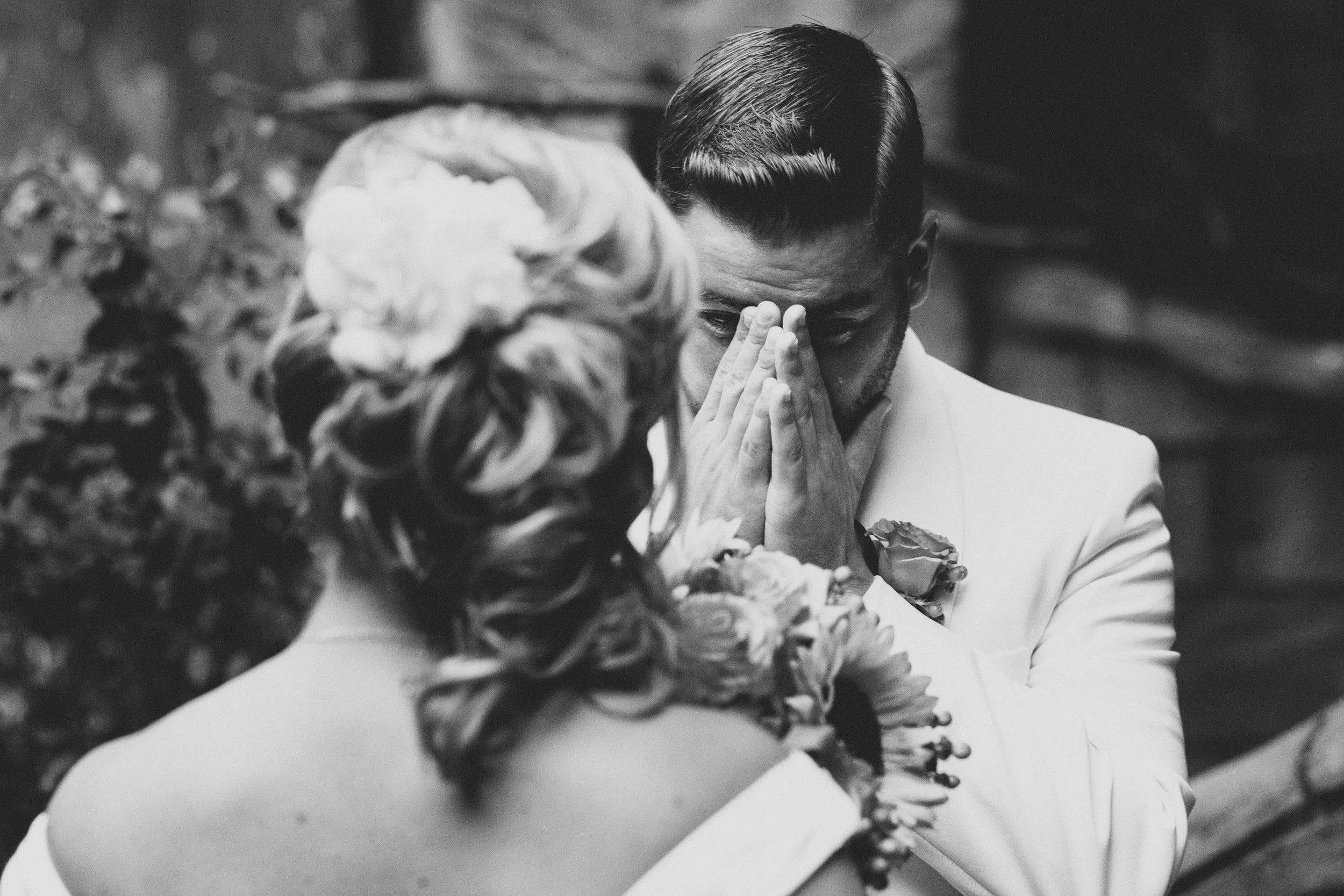 groom is shedding a tear during the first look at his bride