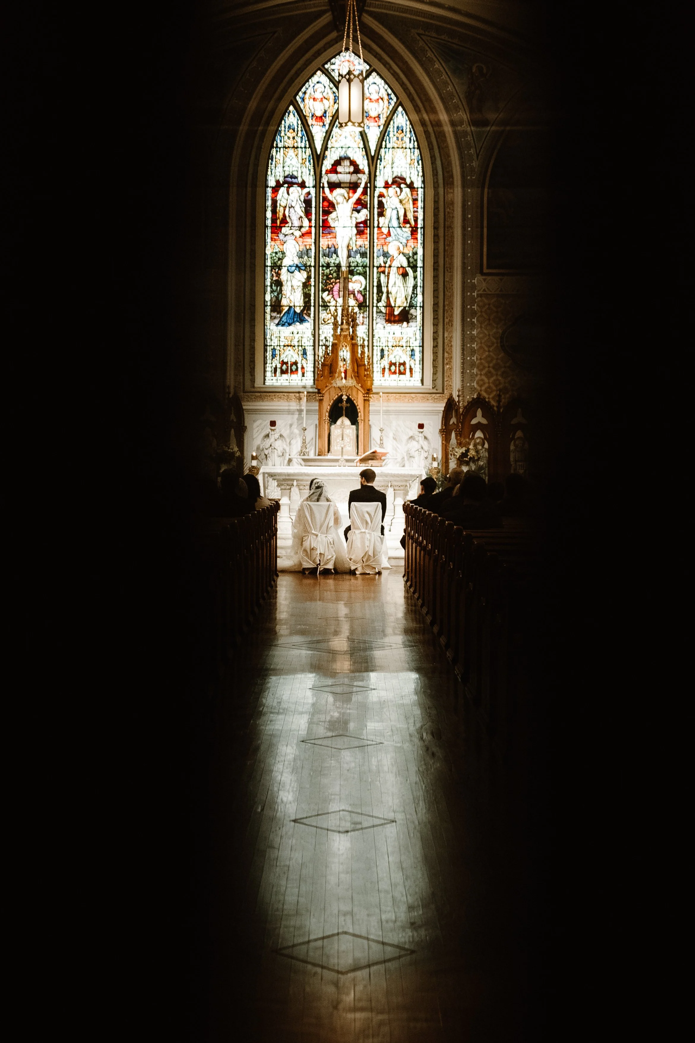 bride and groom seated during ceremony at church