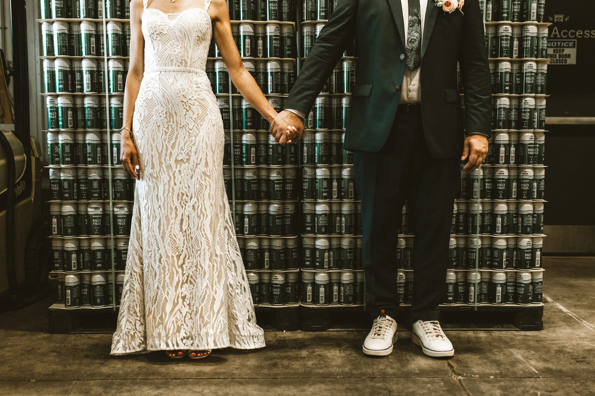 lower body shot of bride and groom in front of beer at bench brewing company