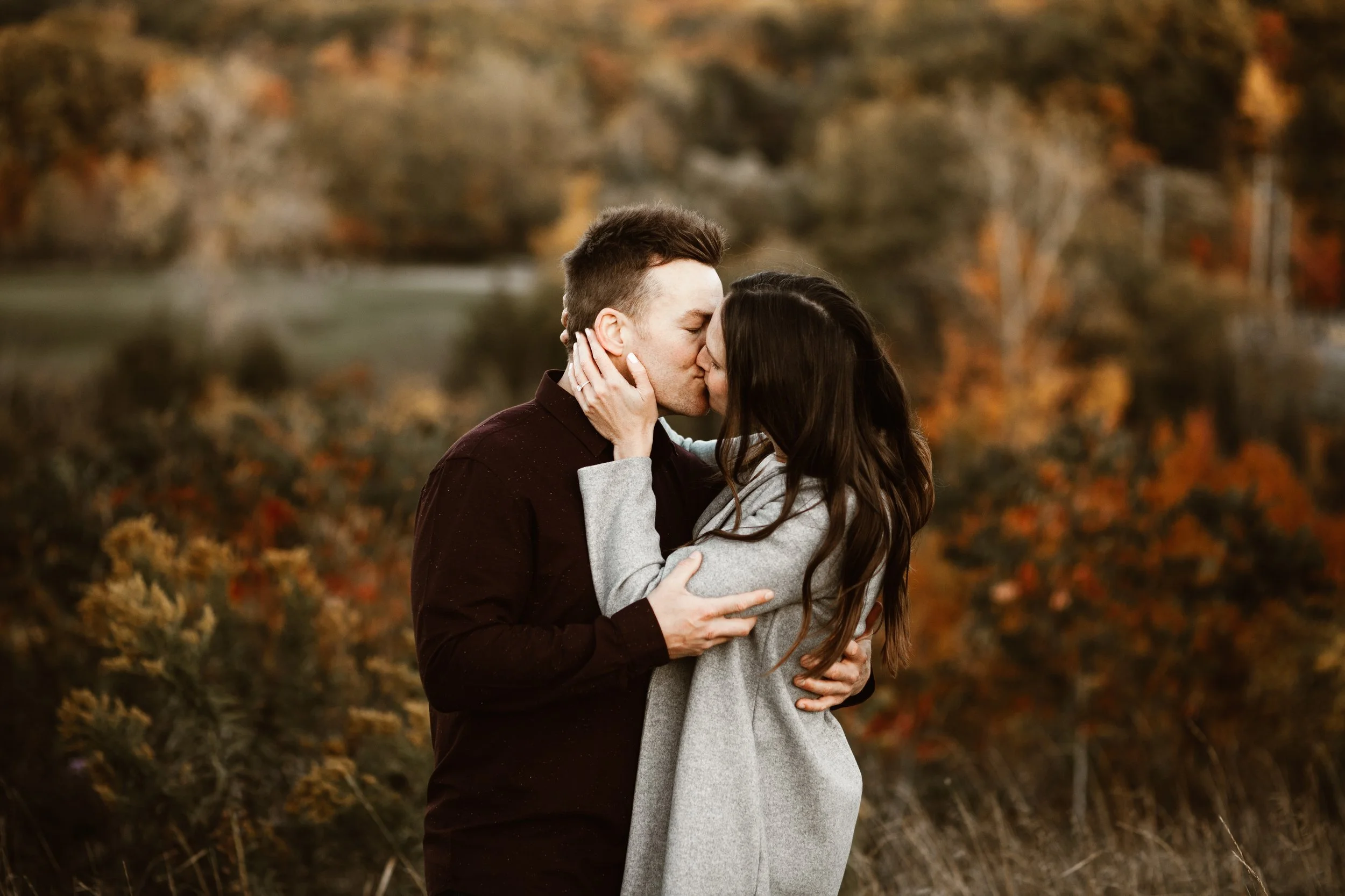 man and woman kissing in fall colours