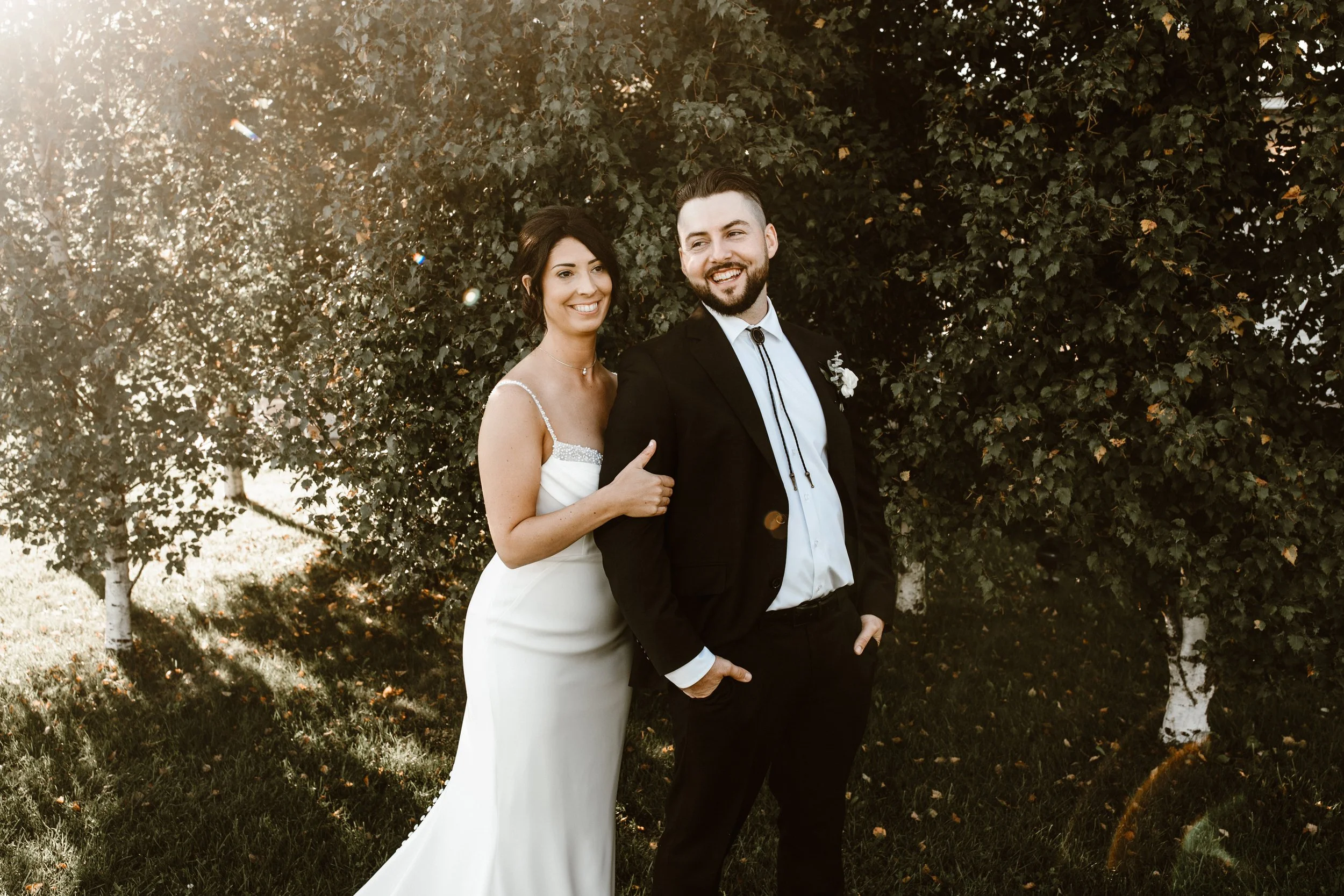 bride and groom all smiles as the sun sets behind them