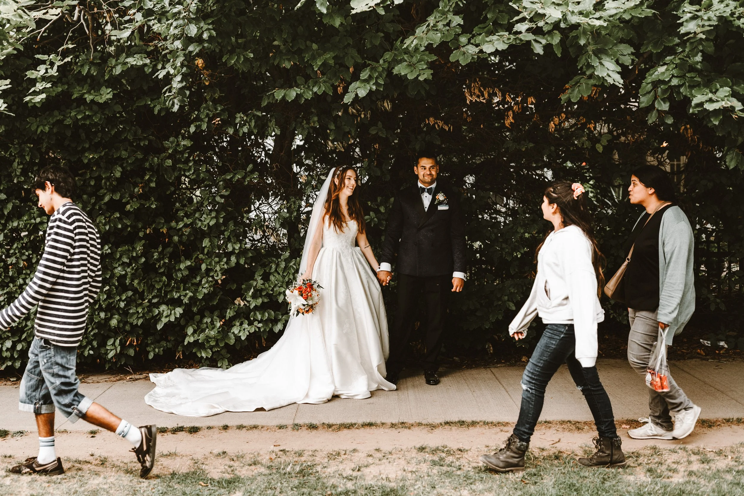 teenagers walk through photo of bride and groom 