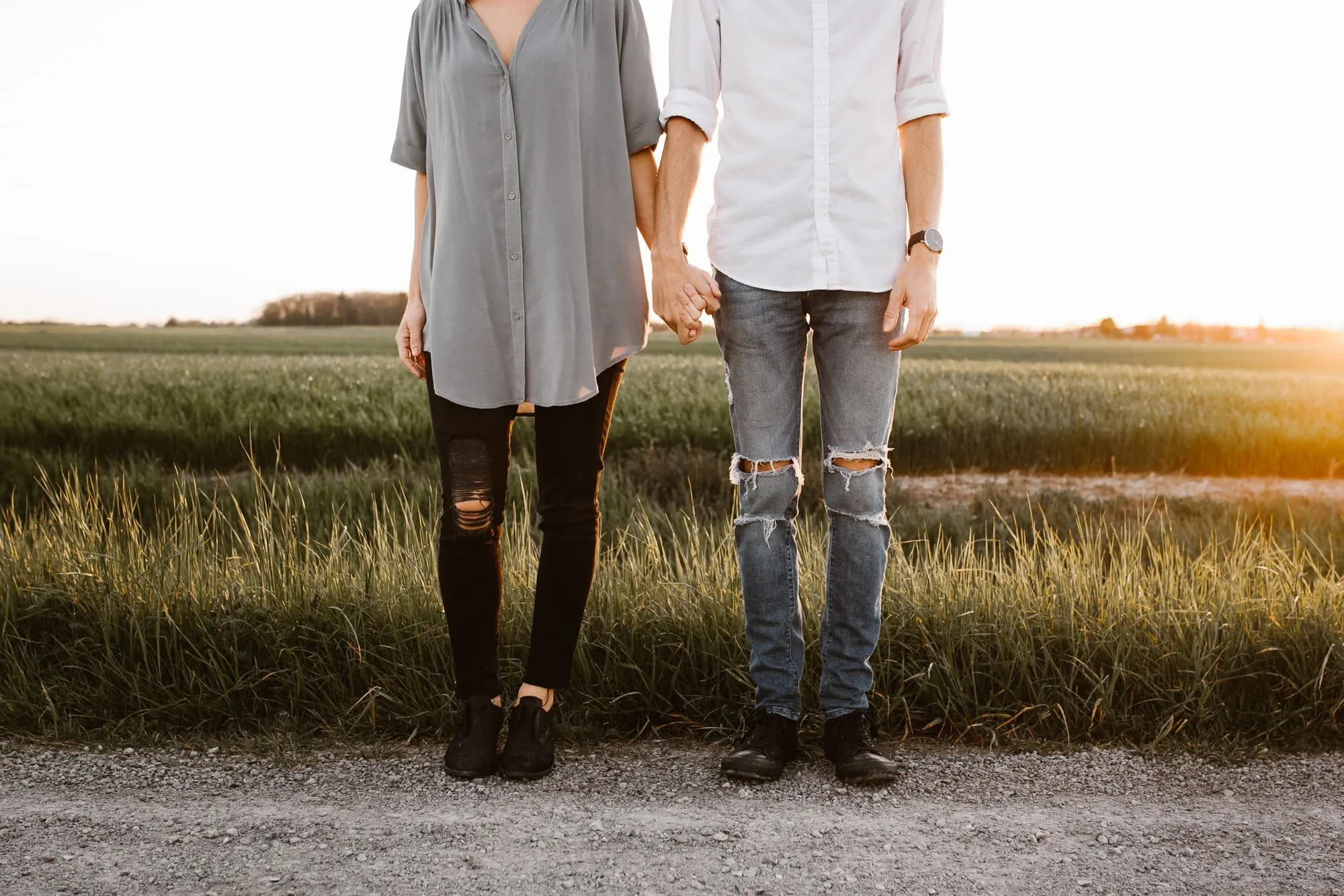 urban clothed couple juxtaposed again field at sunset