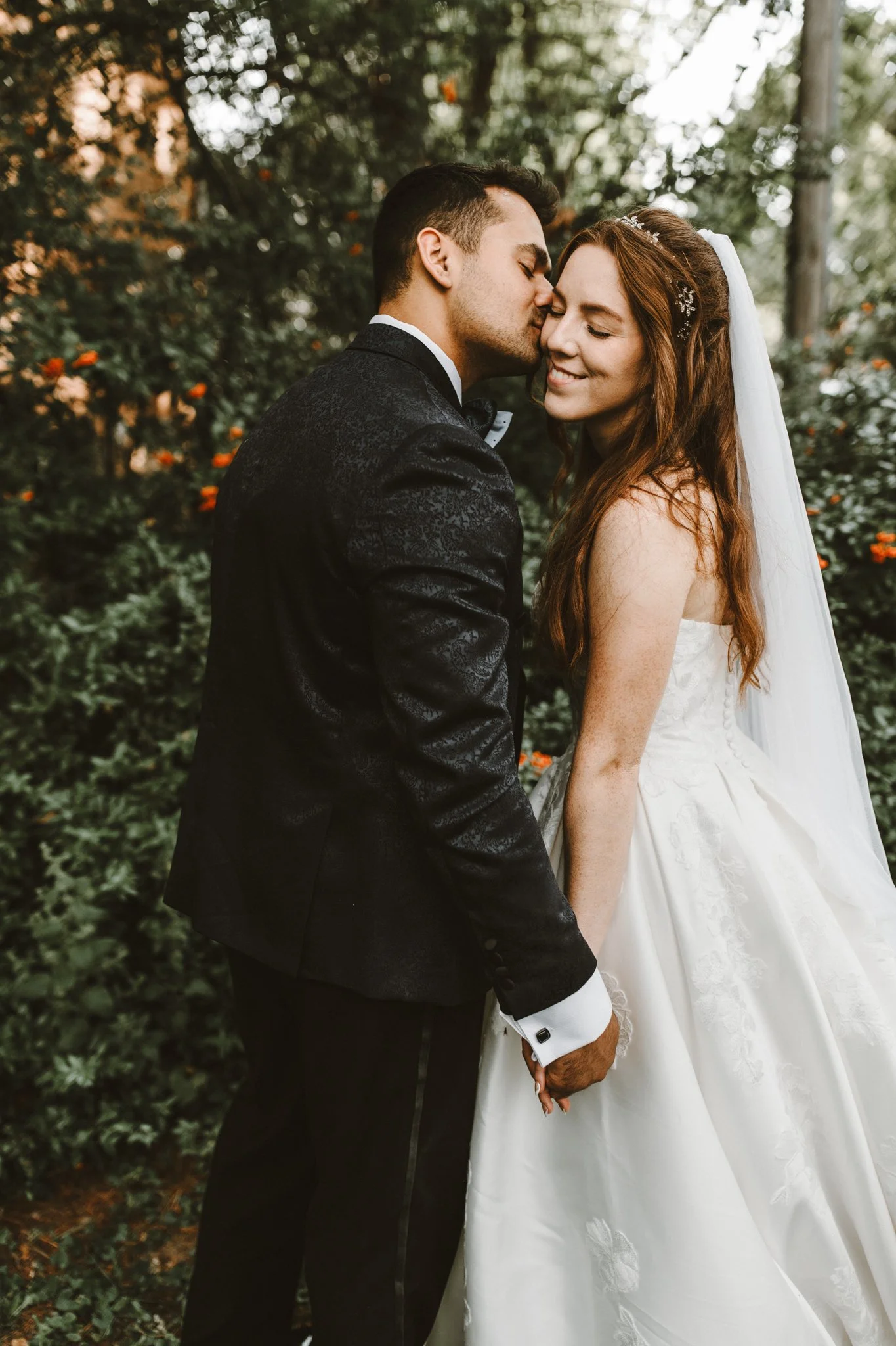 groom kisses his new bride on the forehead