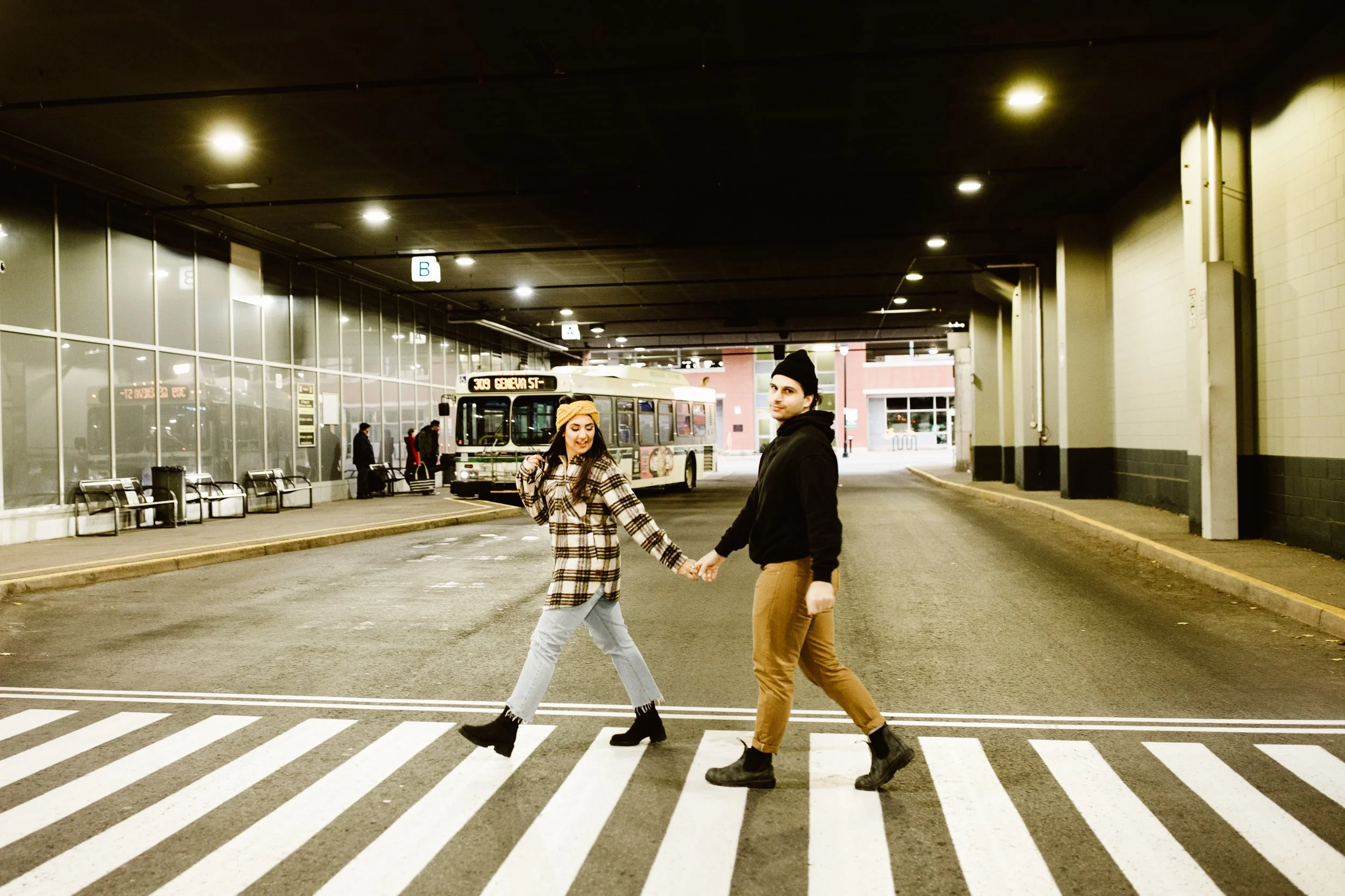 Young engaged couple walking through st. Catharine's Bus Station Beatles style