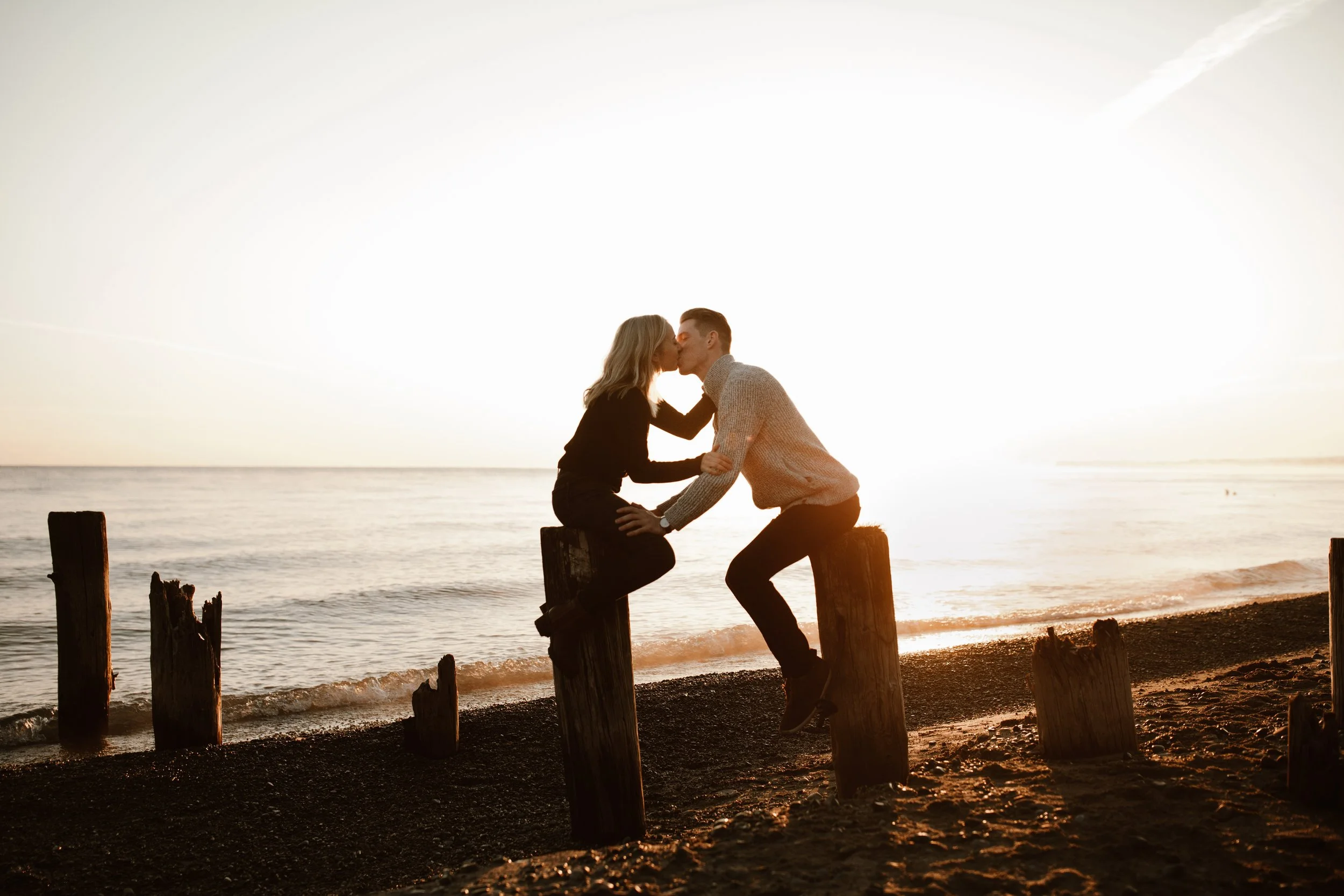 couple kissing lakeside during sunrise
