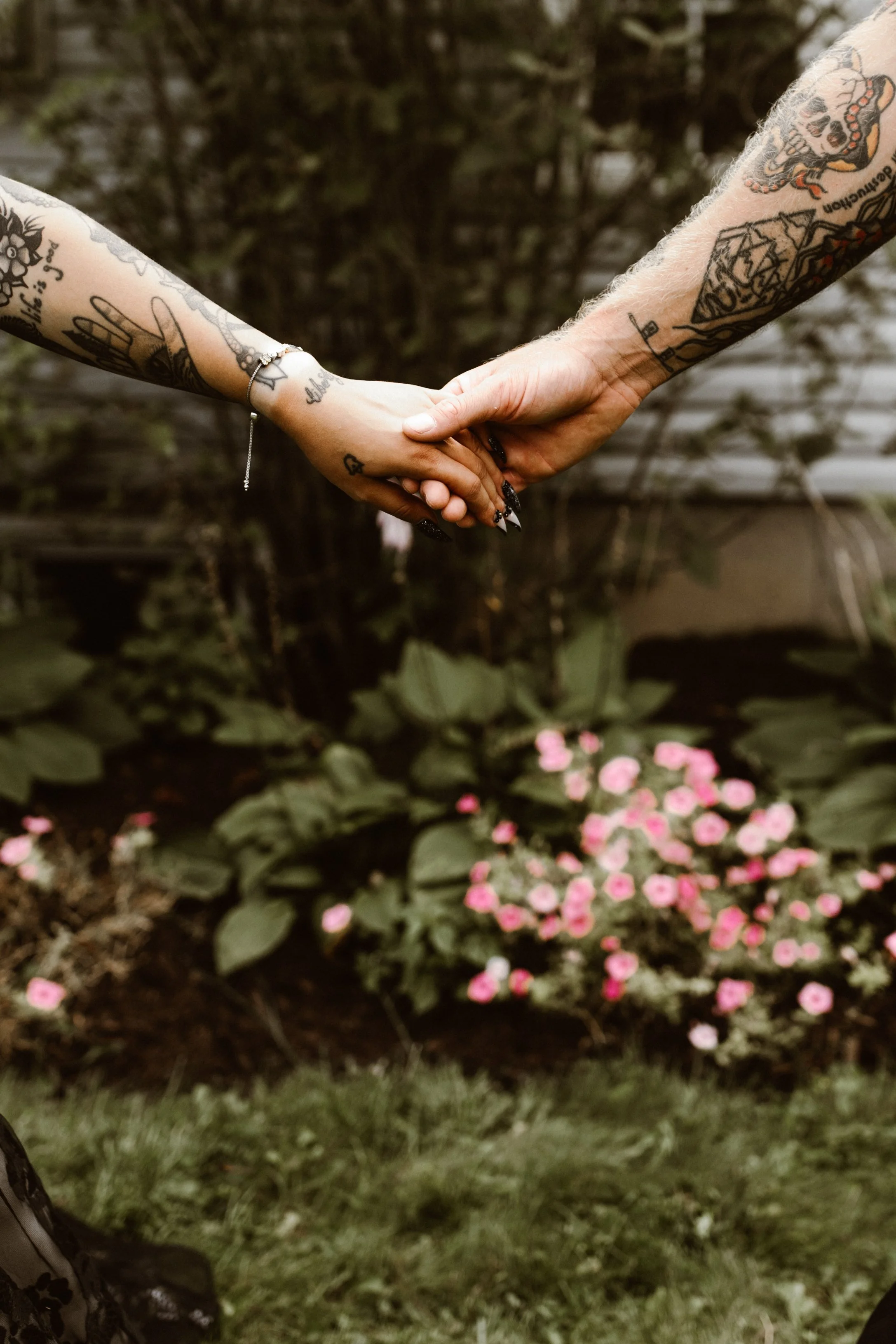tattooed couple holding hands