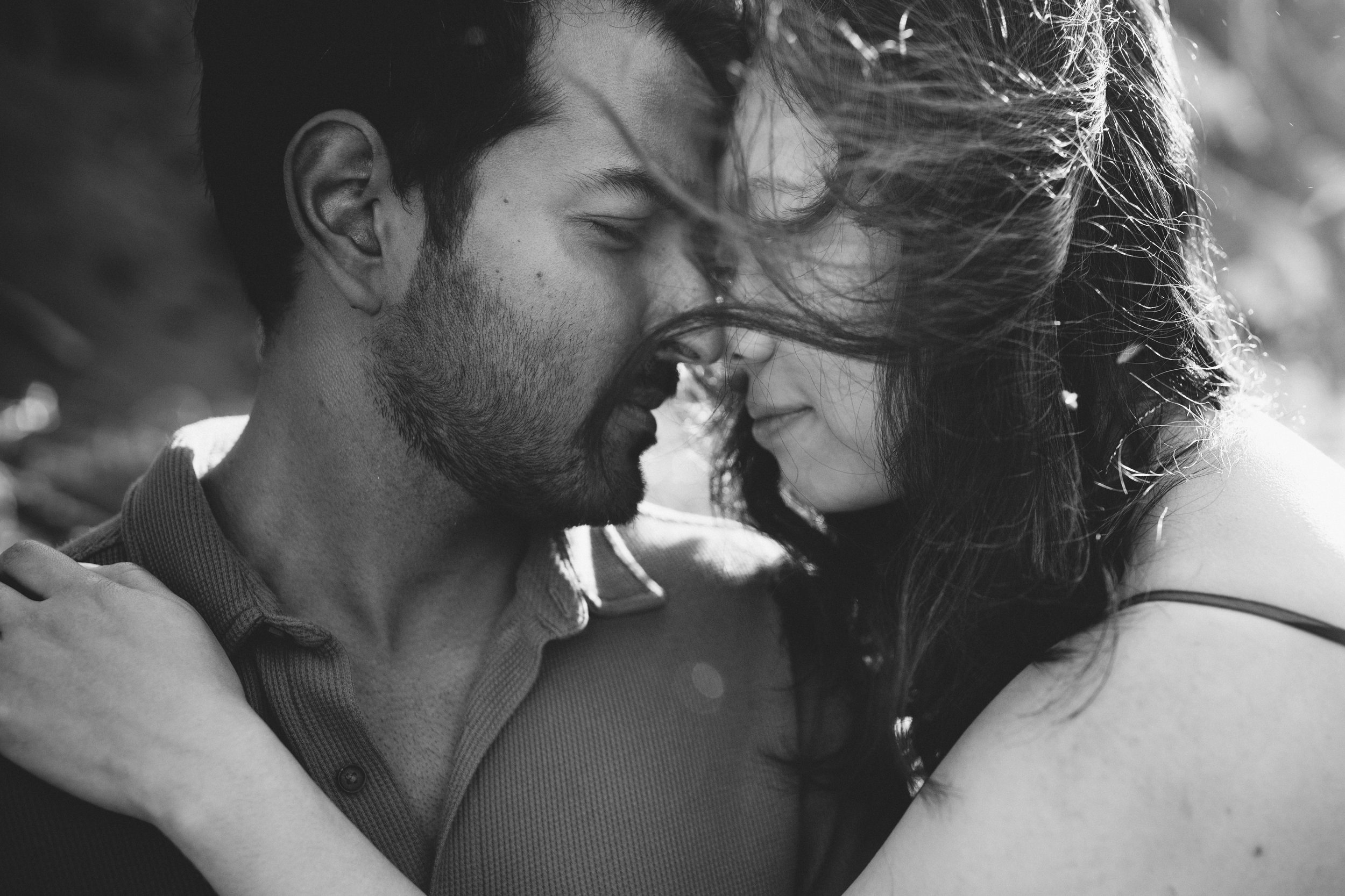 couple hold each other with wind swept hair 