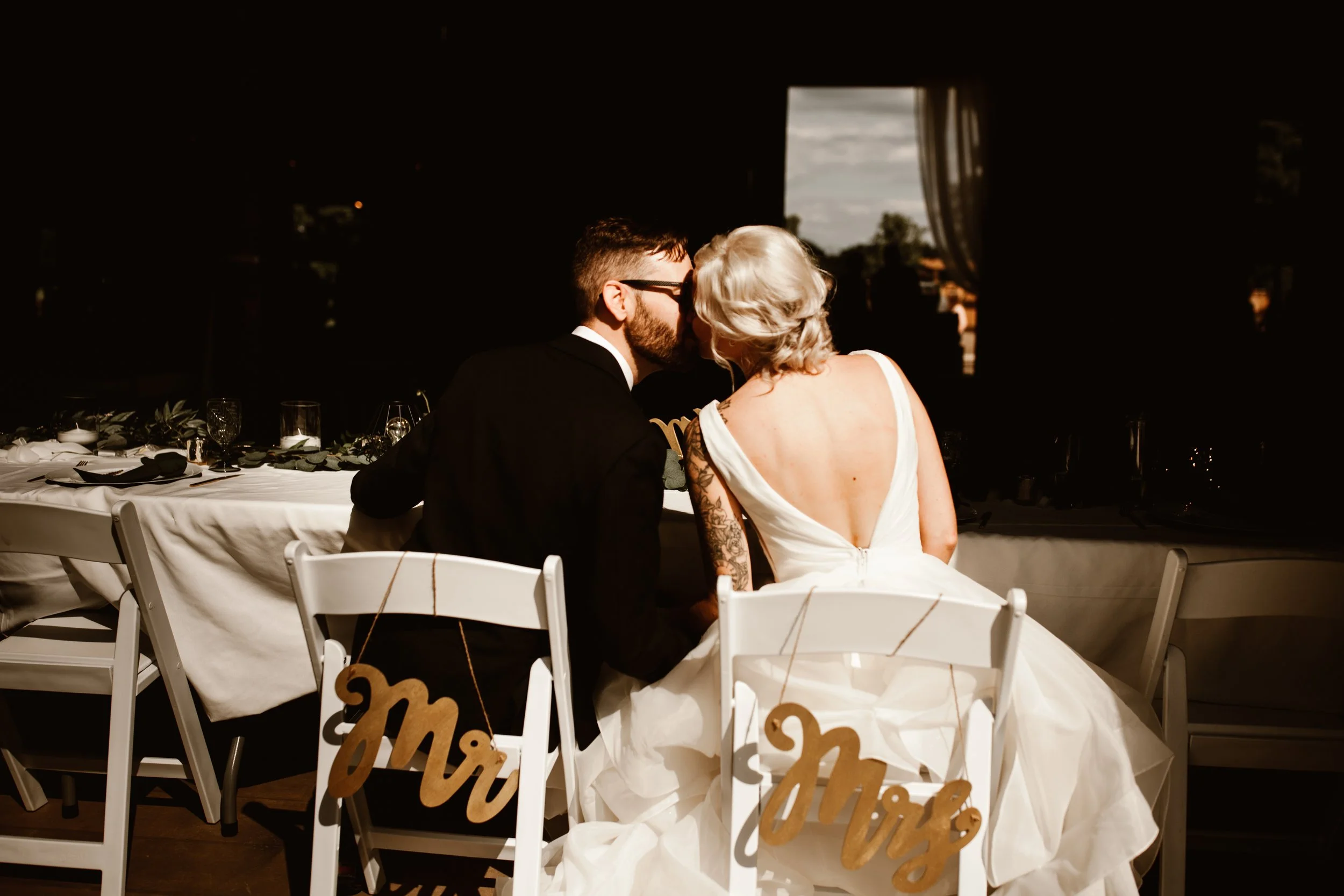 bride and groom kissing from behind