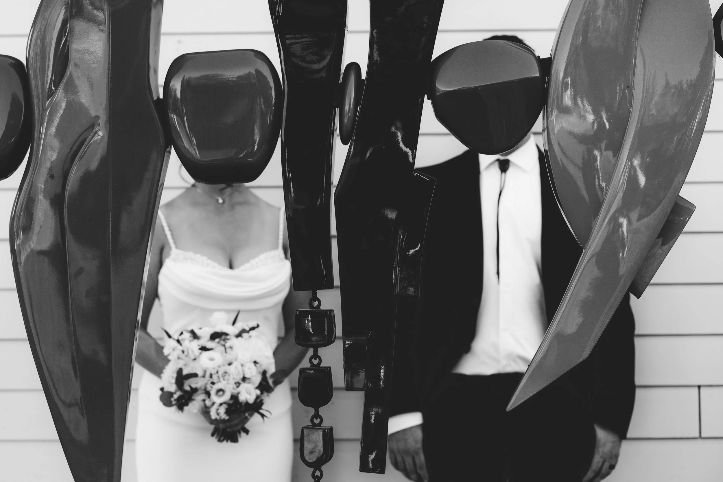 bride and groom posing with abstract art at 13th street winery