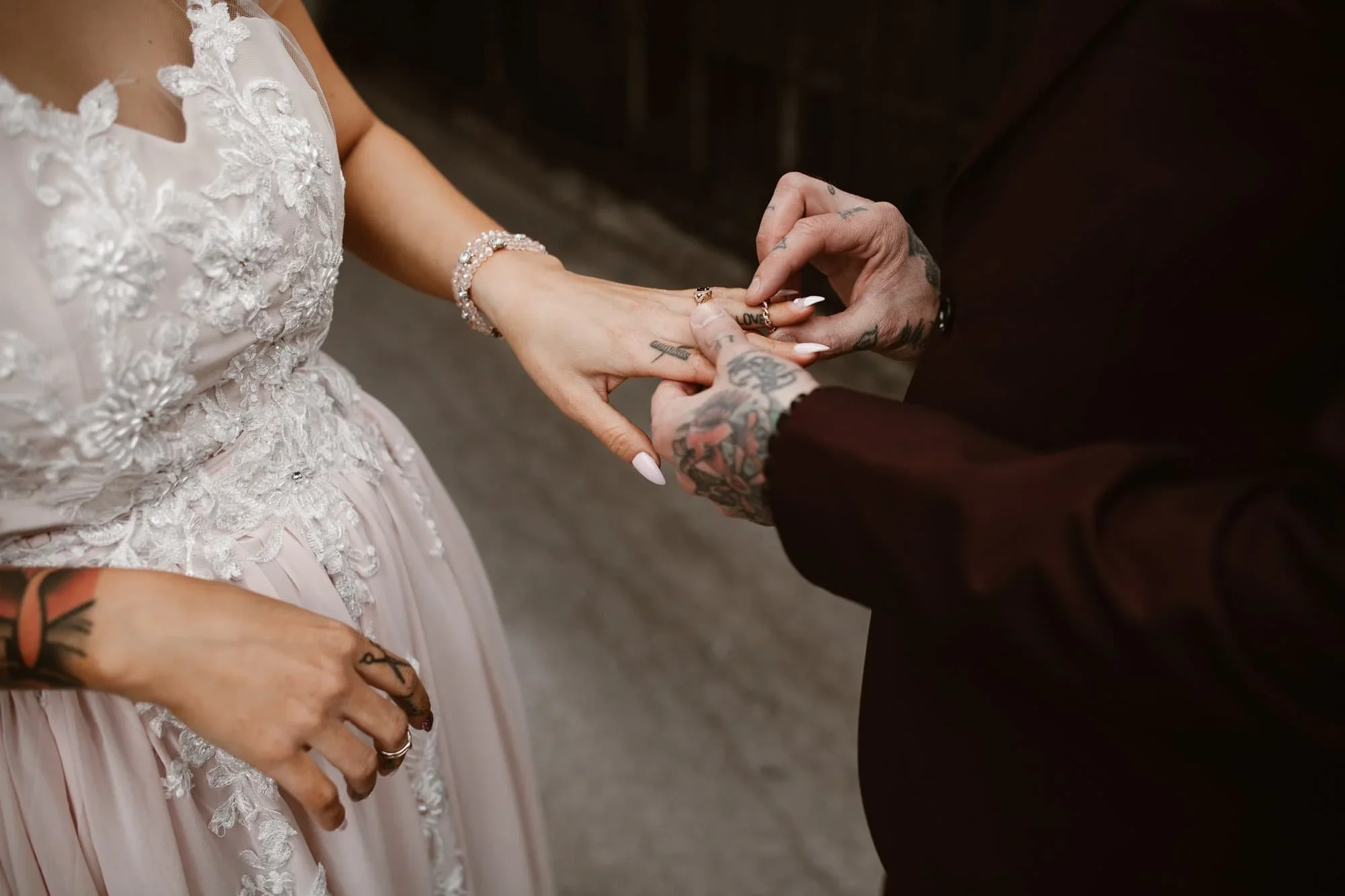 tattooed couple exchanging rings