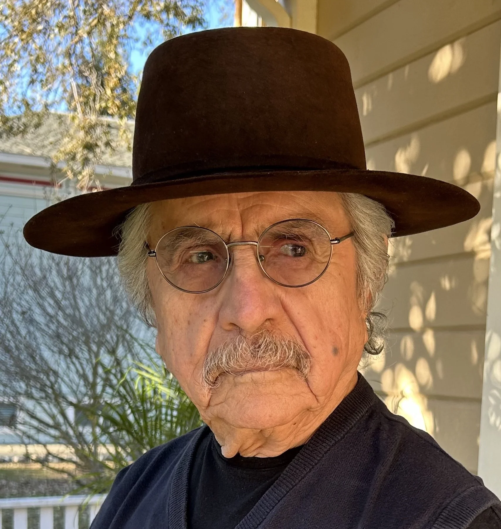 Portrait of the Artist Malaquias Montoya wearing his signature hat.