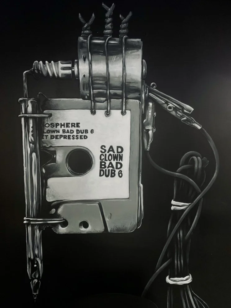 Black-and-white illustration of a handmade electronic music device labeled “Sad Clown Bad Dub 6,” with wires, clips, and metal components.